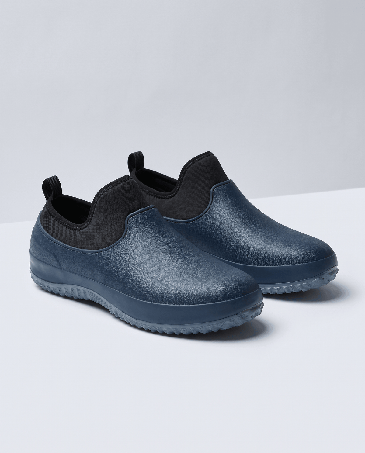 Pair of navy blue slip-on shoes with black stretch collar and grey sole