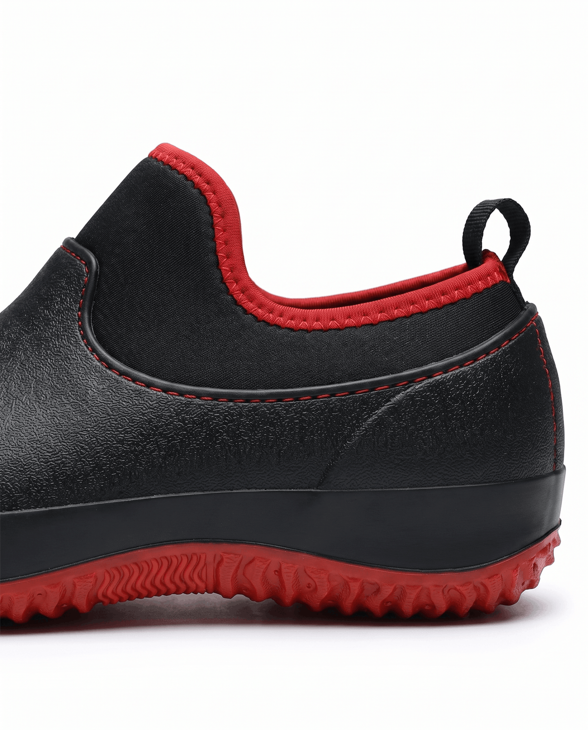 Close view of black shoe collar with rear pull loop and red trim