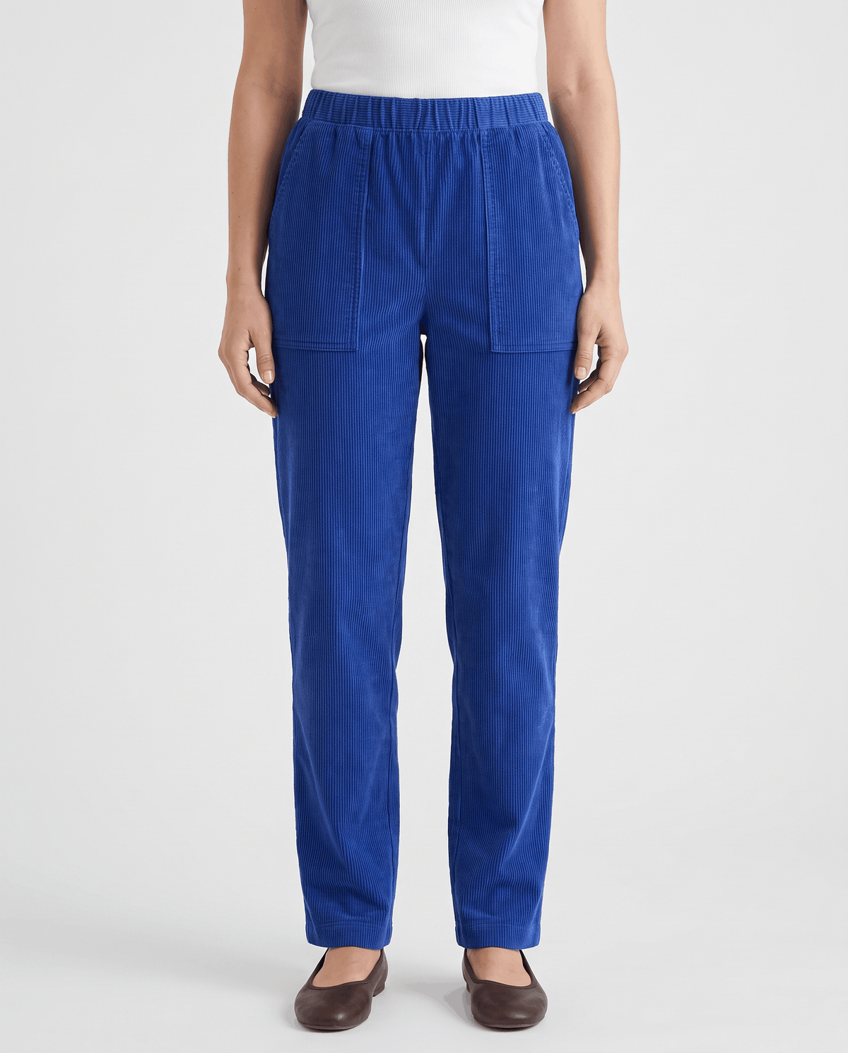 Front view of royal blue ribbed pull-on pants worn with a white top and flats