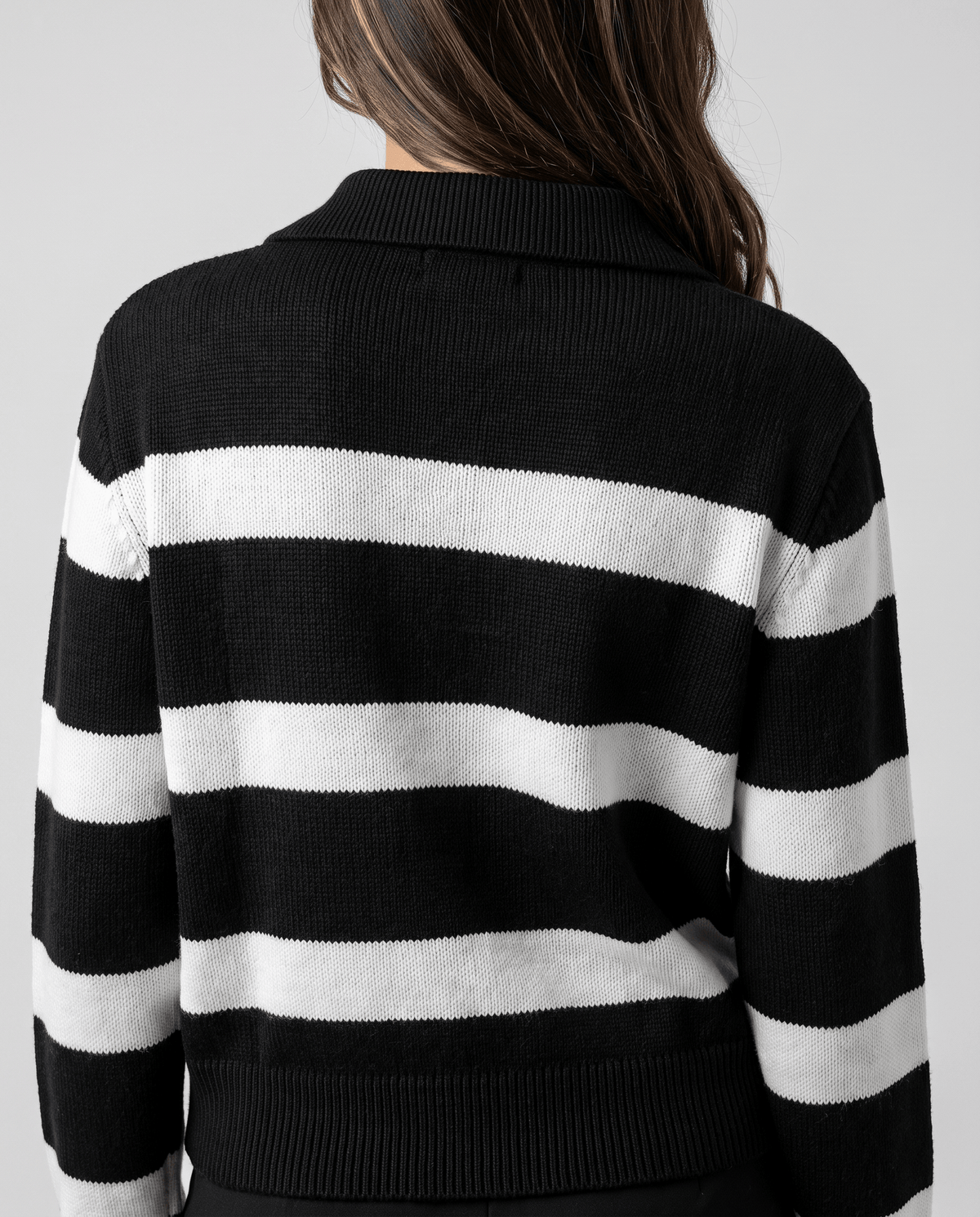 Back view of black and white striped sweater showing ribbed hem and cuffs