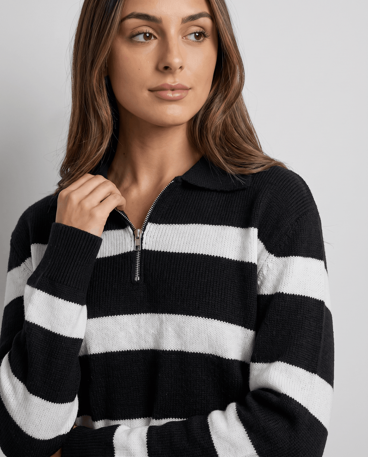 Close-up of model at the polo collar of a black and white striped sweater