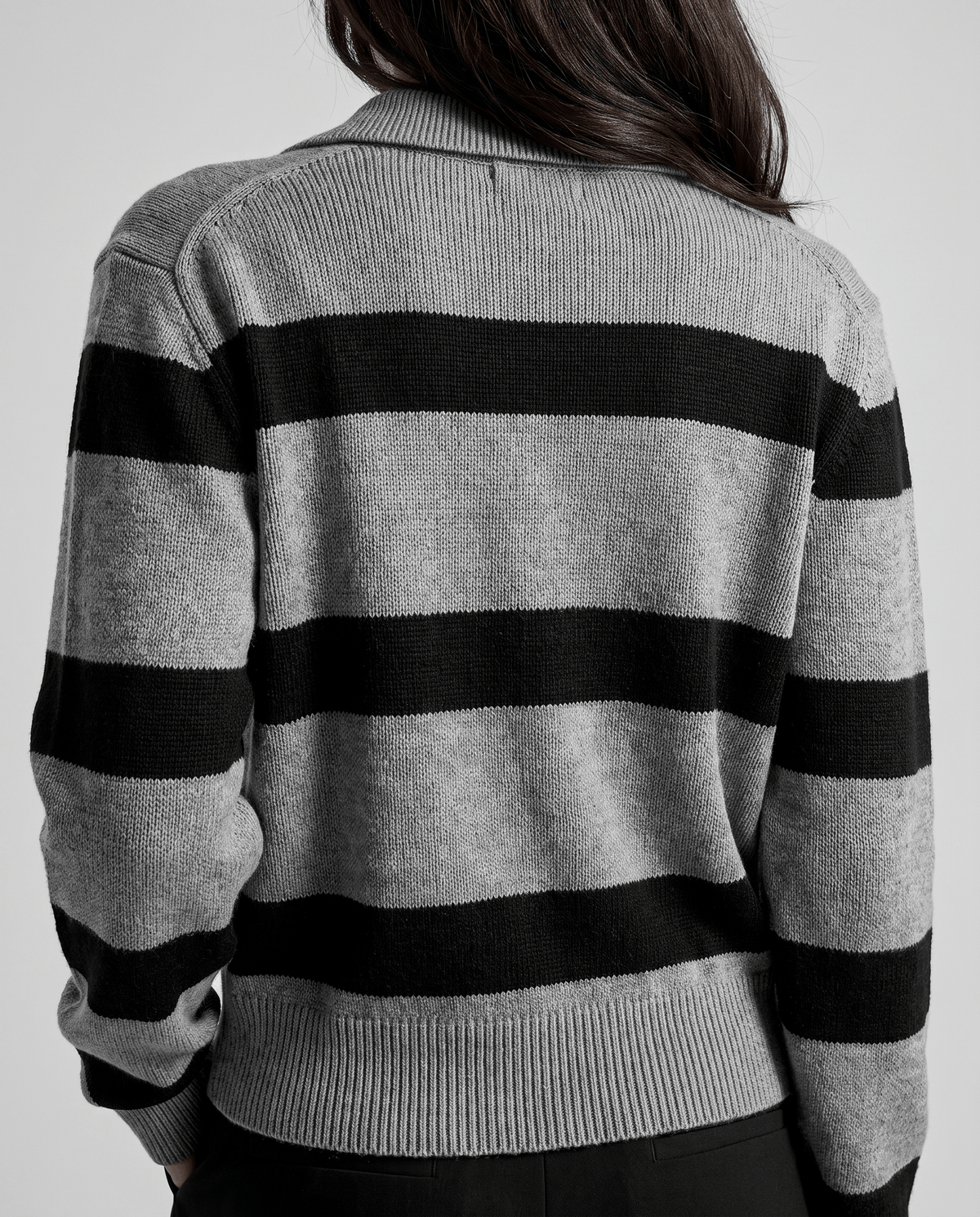 Back view of gray and black striped sweater with ribbed cuffs and hem