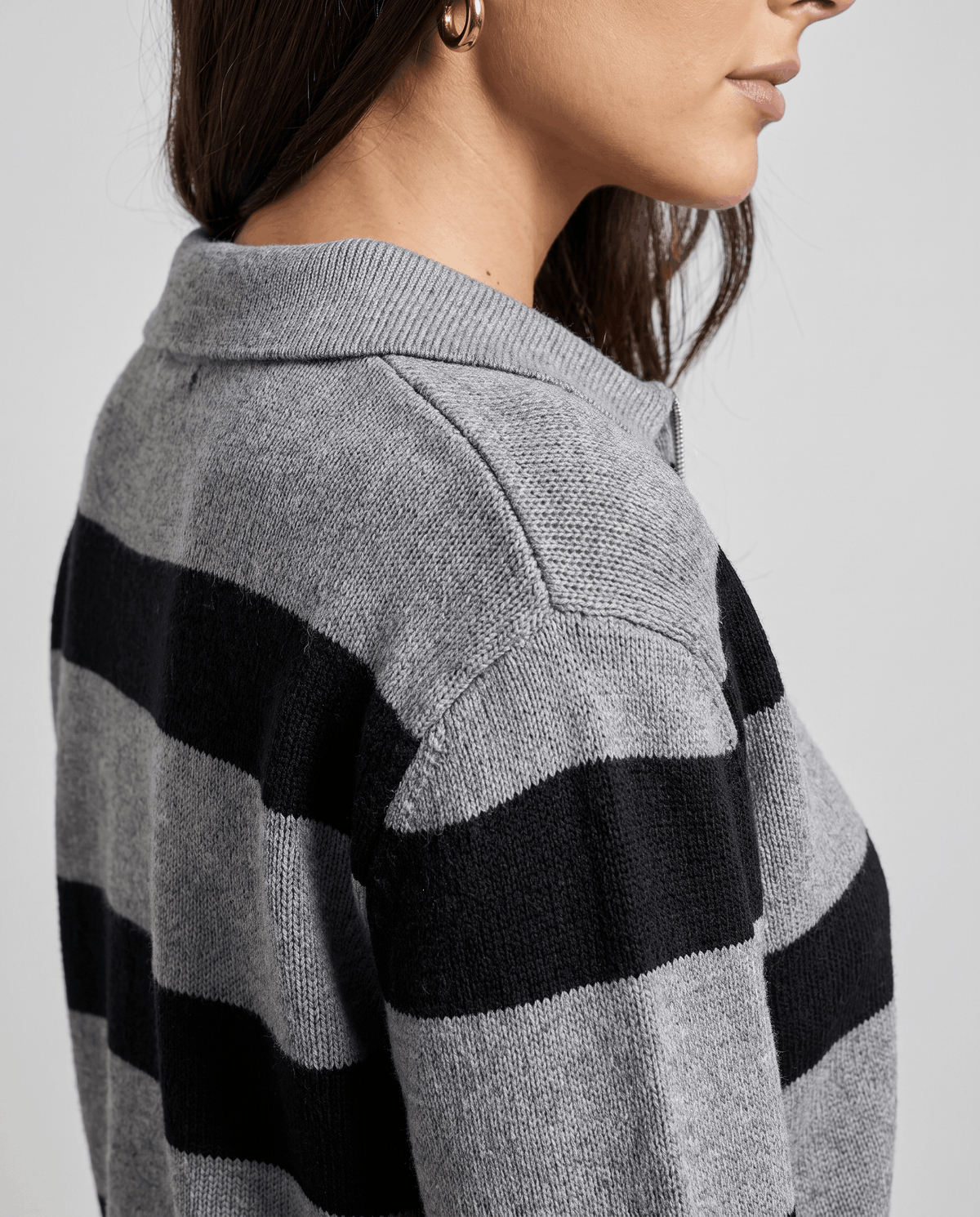 Side shoulder detail of gray knit with wide black stripes