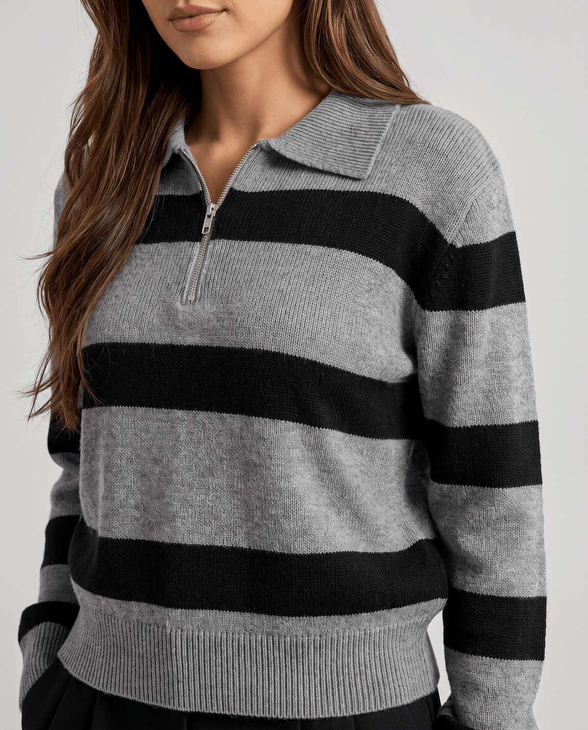 Cropped front view of gray striped knit sweater with pointed collar and zip