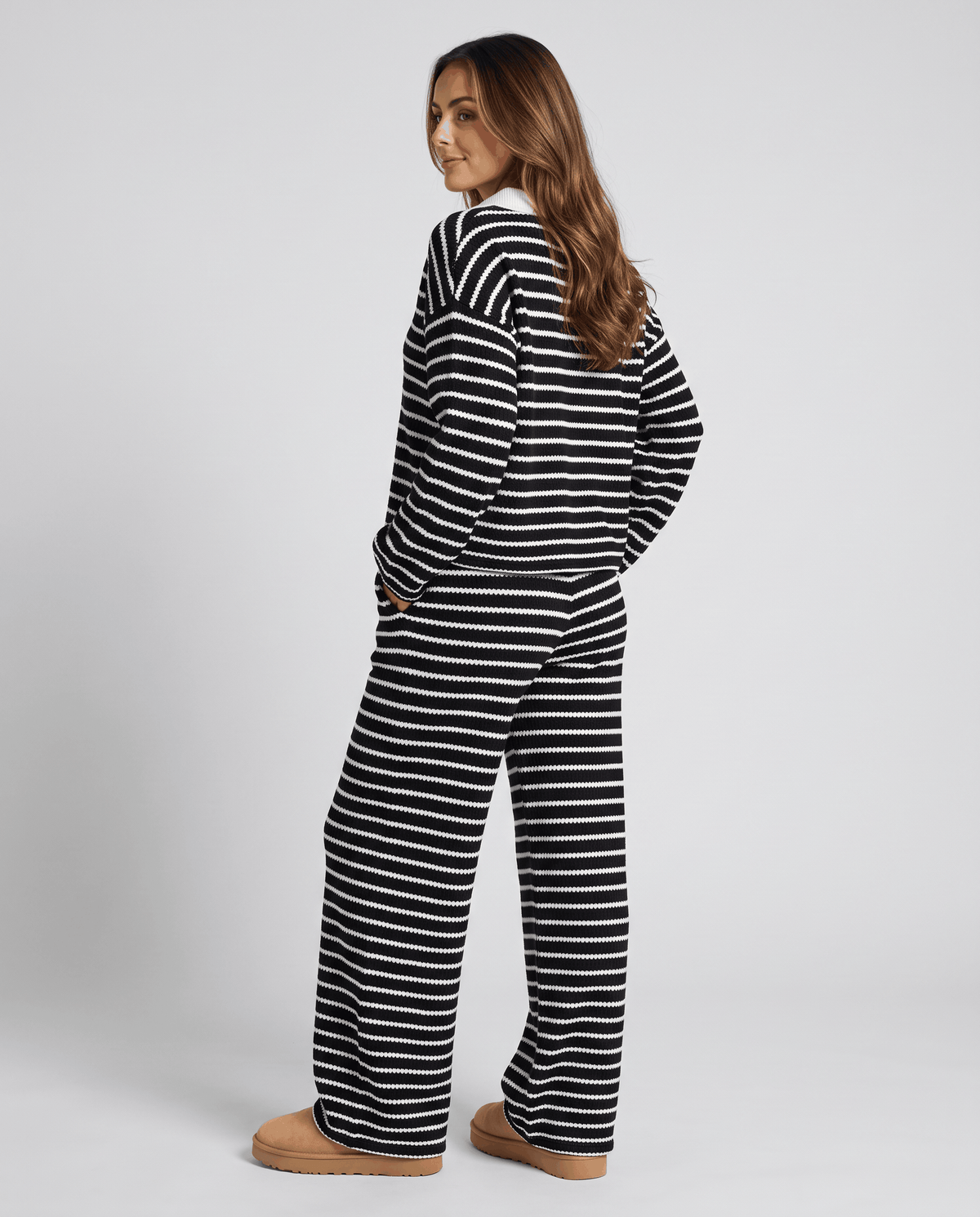 Back view of woman in black striped knit top and wide-leg pants