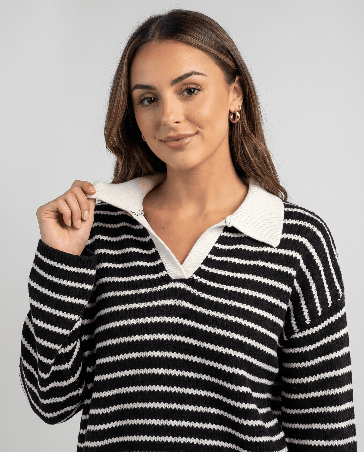 Close-up of black striped knit top with white collar and V-neckline