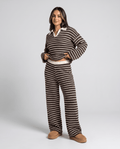 Woman wearing a brown striped loungewear set with collared V-neck knit top and wide-leg pants