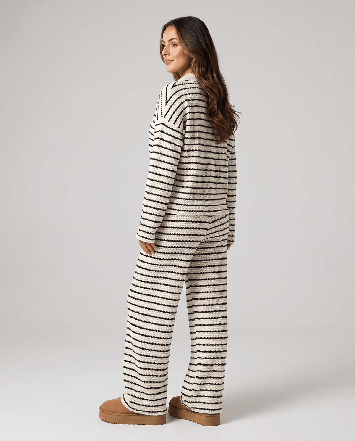 Back view of woman in cream striped knit top and wide-leg pants