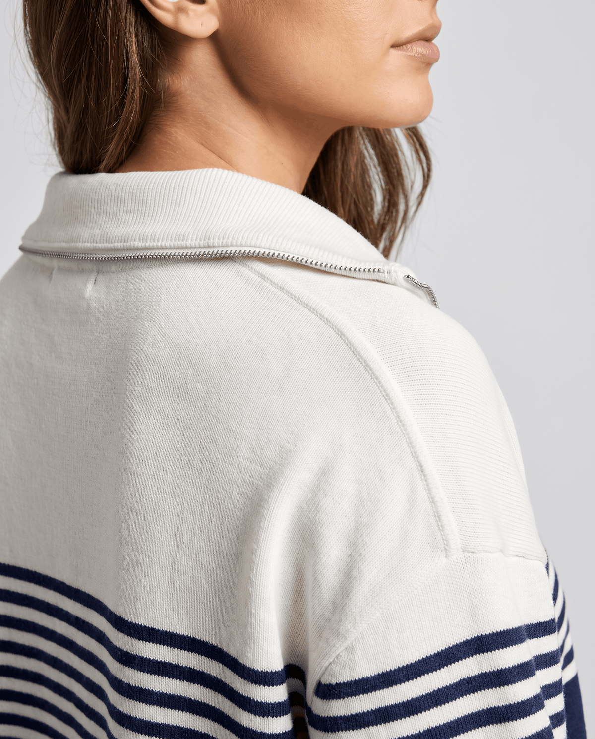 Close-up of ivory collar and navy stripes on the sleeve of a knit pullover