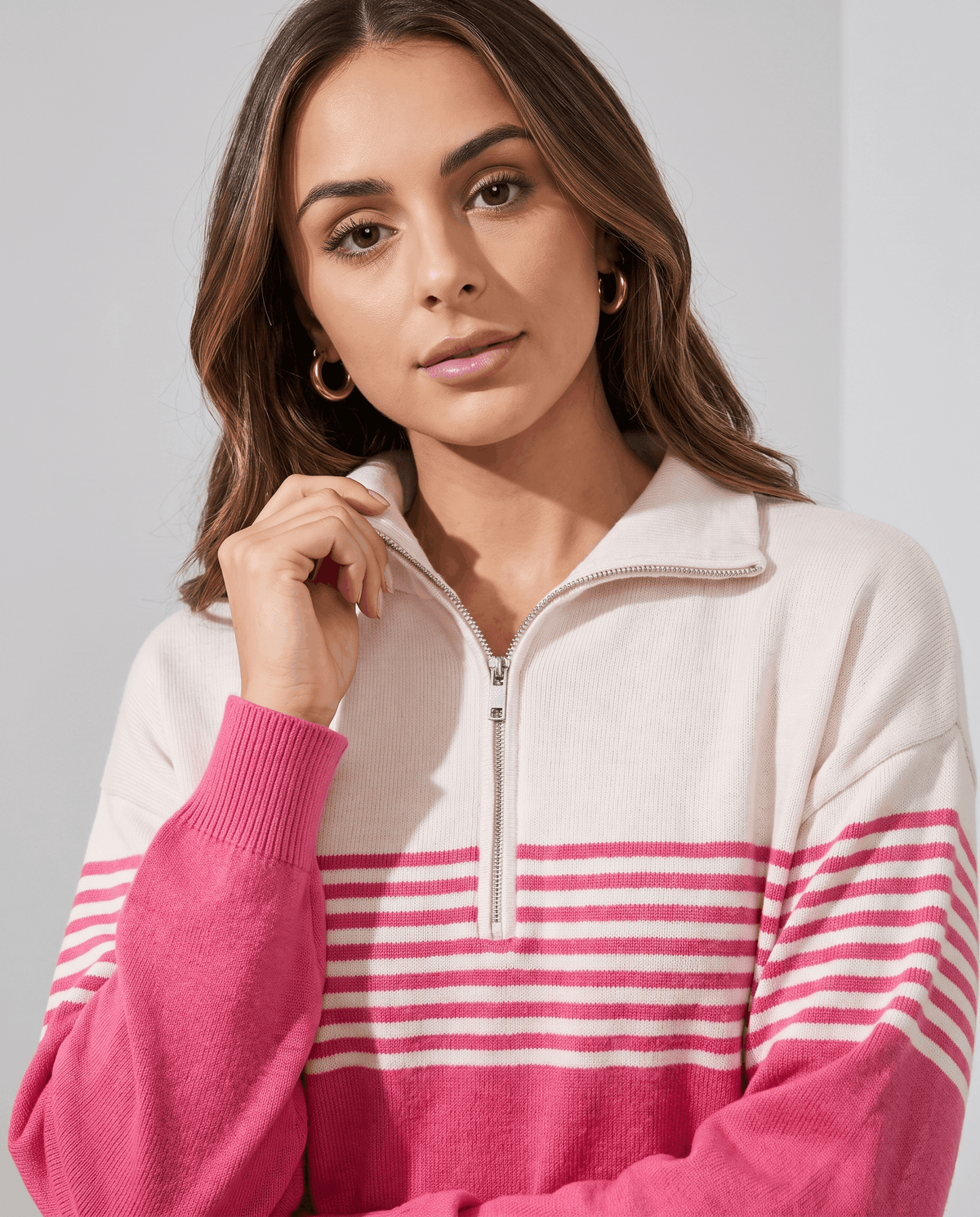 Close-up of ivory fold-over collar and zip on a fuchsia striped knit pullover