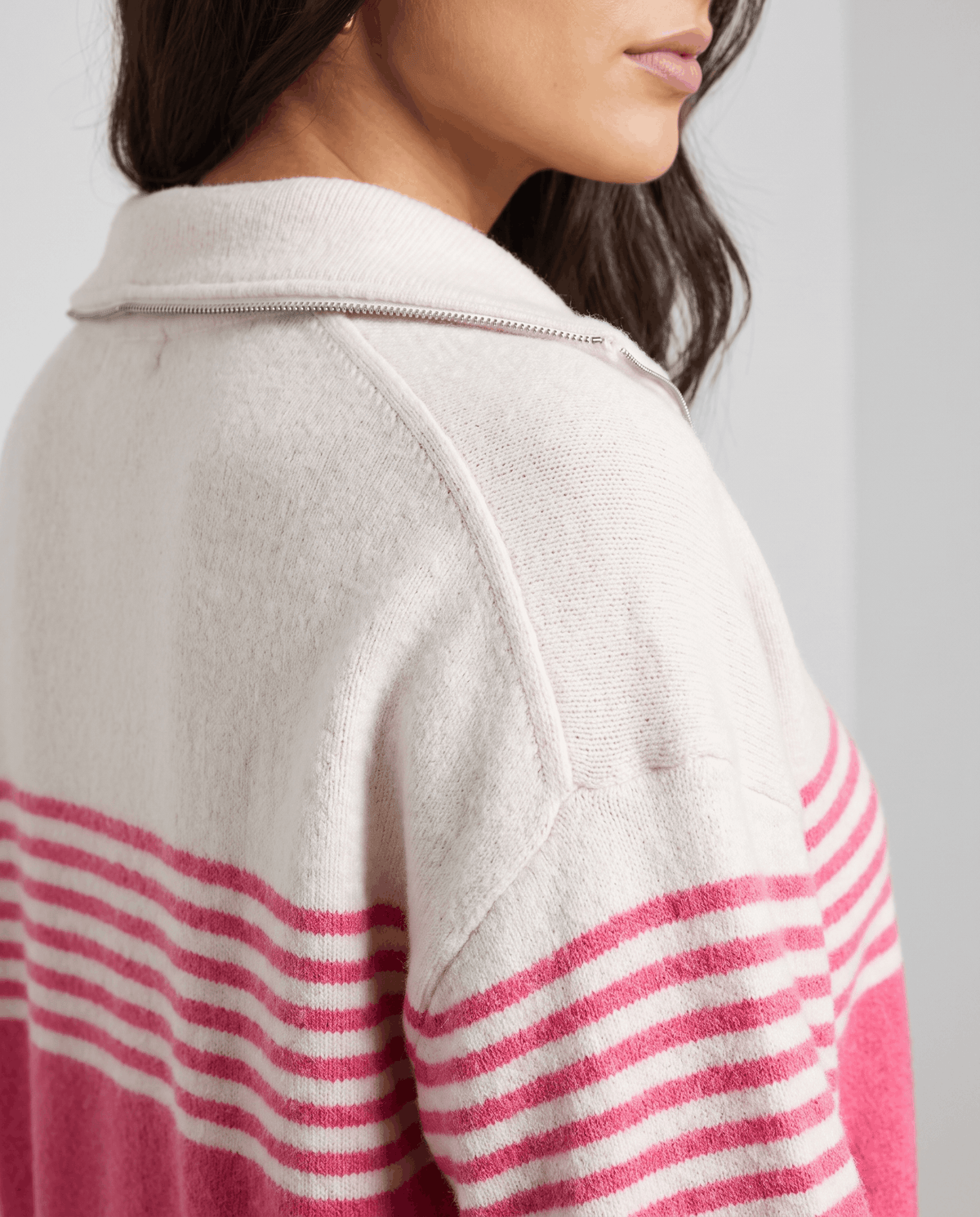 Shoulder detail showing fuchsia and pink stripes on an ivory drop-shoulder sleeve