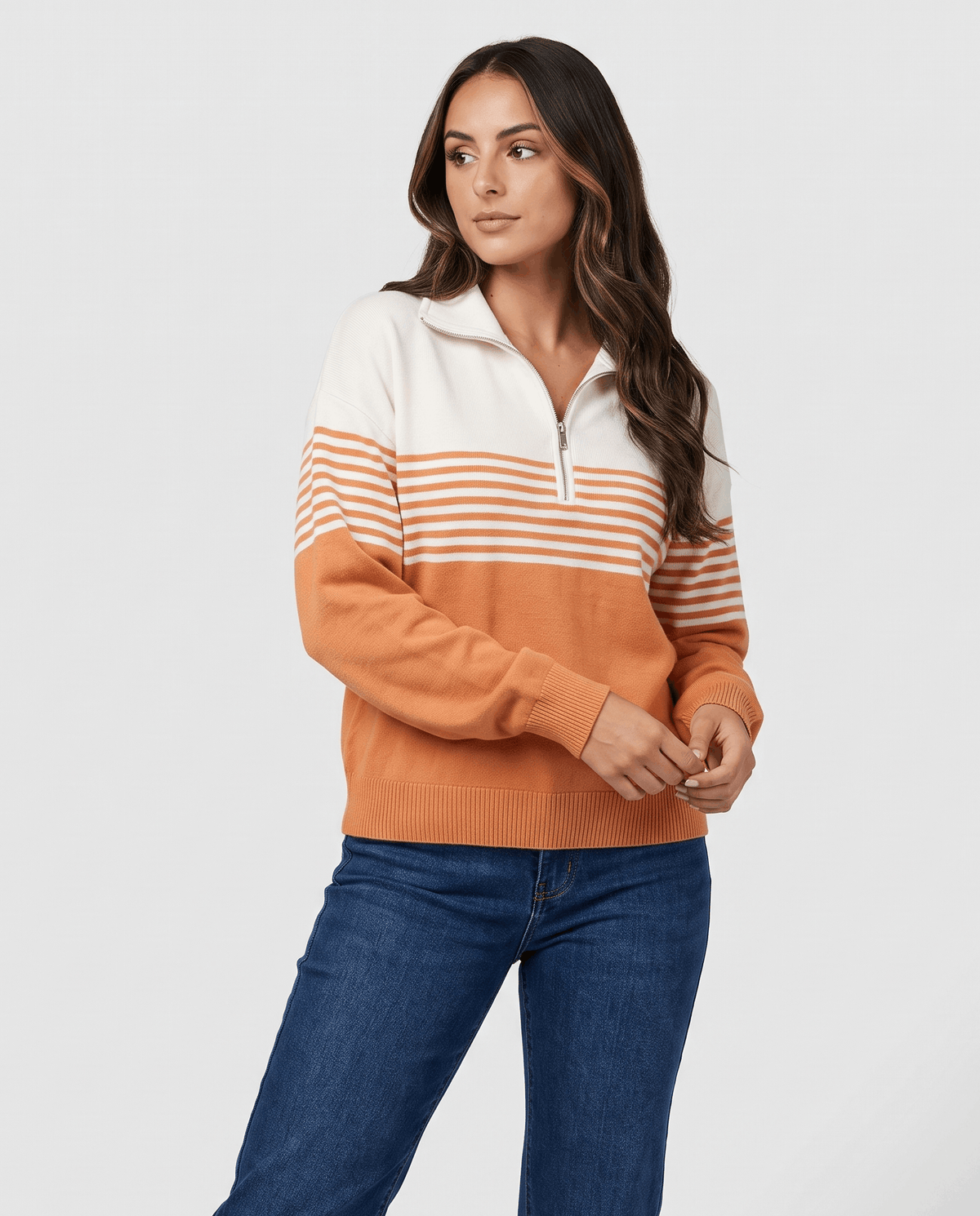Orange and ivory striped pullover worn with medium wash jeans, front view