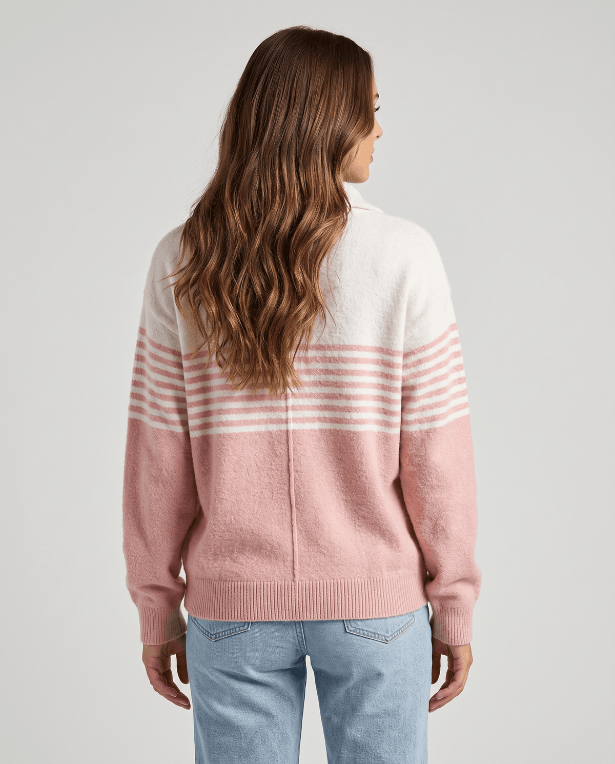 Back view of light pink striped pullover worn with light wash jeans