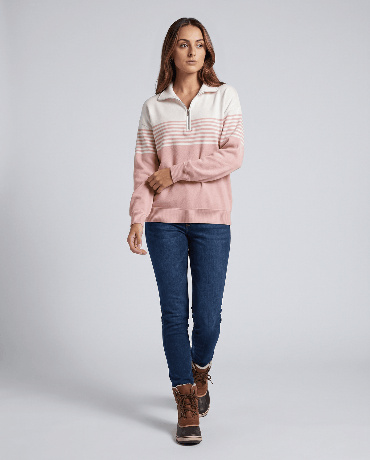Full-length view of light pink pullover with dark jeans and brown ankle boots