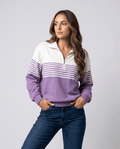 Woman wearing a purple striped quarter-zip sweater with jeans, hands in pockets