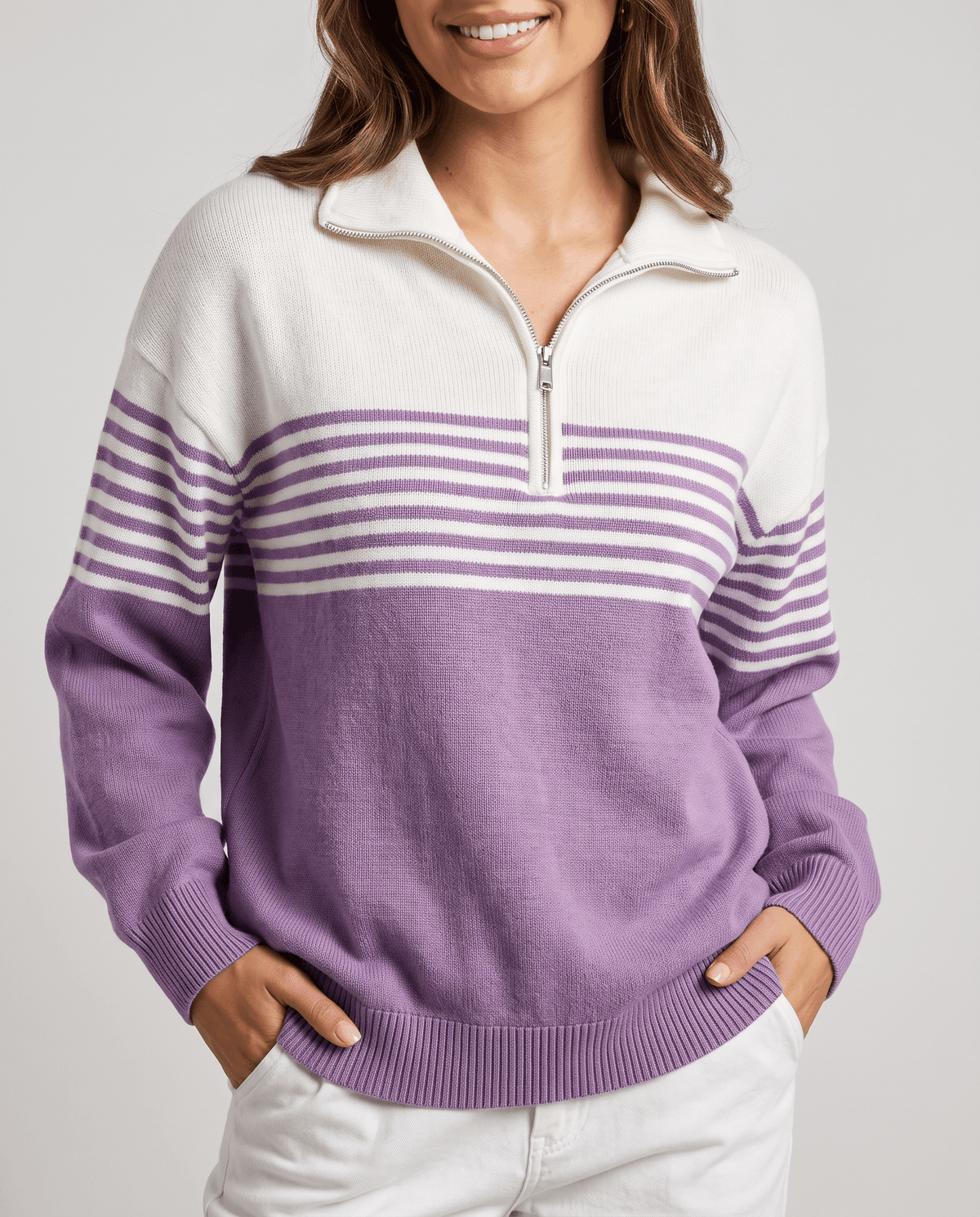 Front view of purple and ivory color-block pullover with half-open zip and white pants