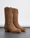 Pair of women's suede cowboy boots in warm tan with stitched shaft and stacked heel