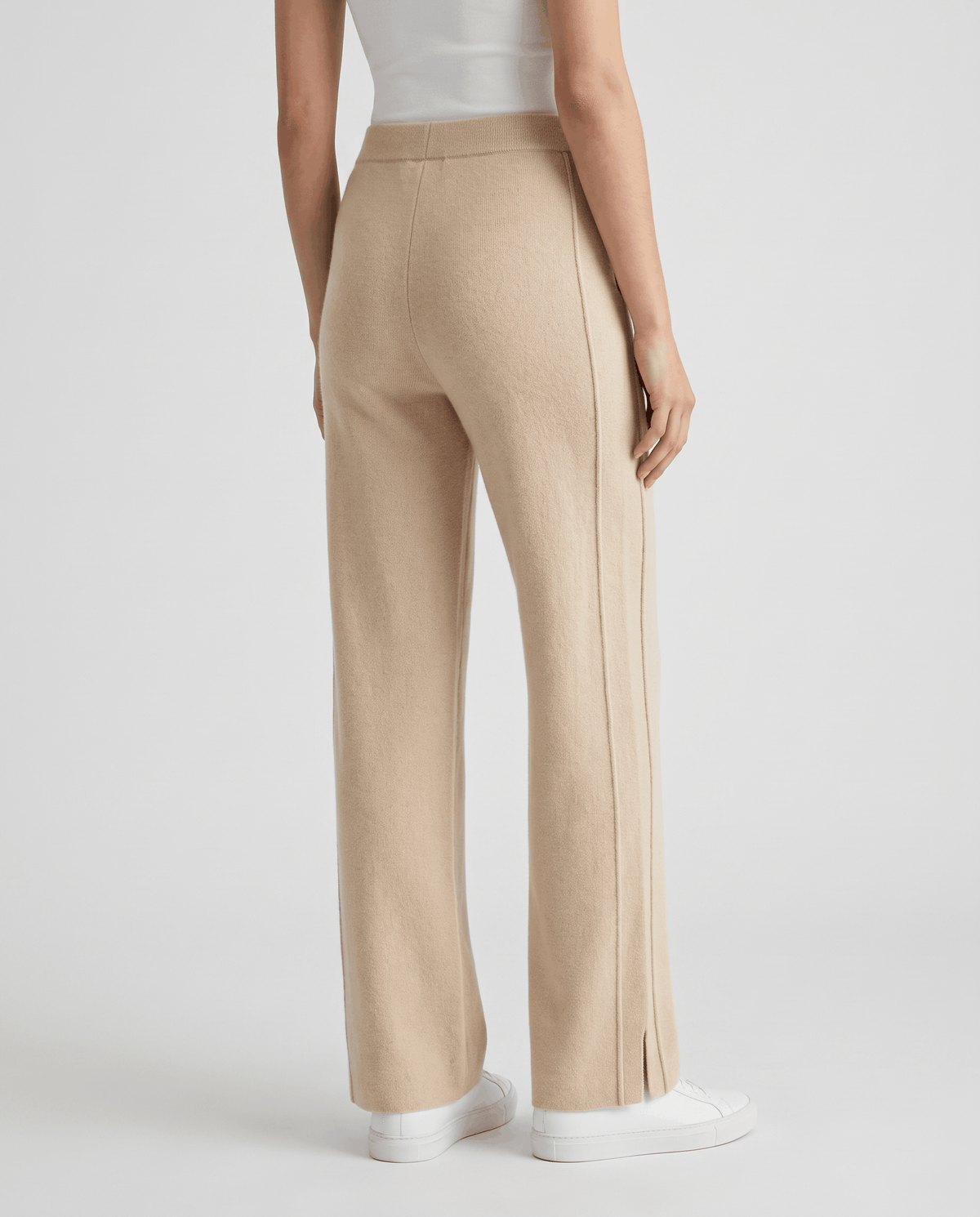 Back view of beige straight-leg pants worn with white sneakers