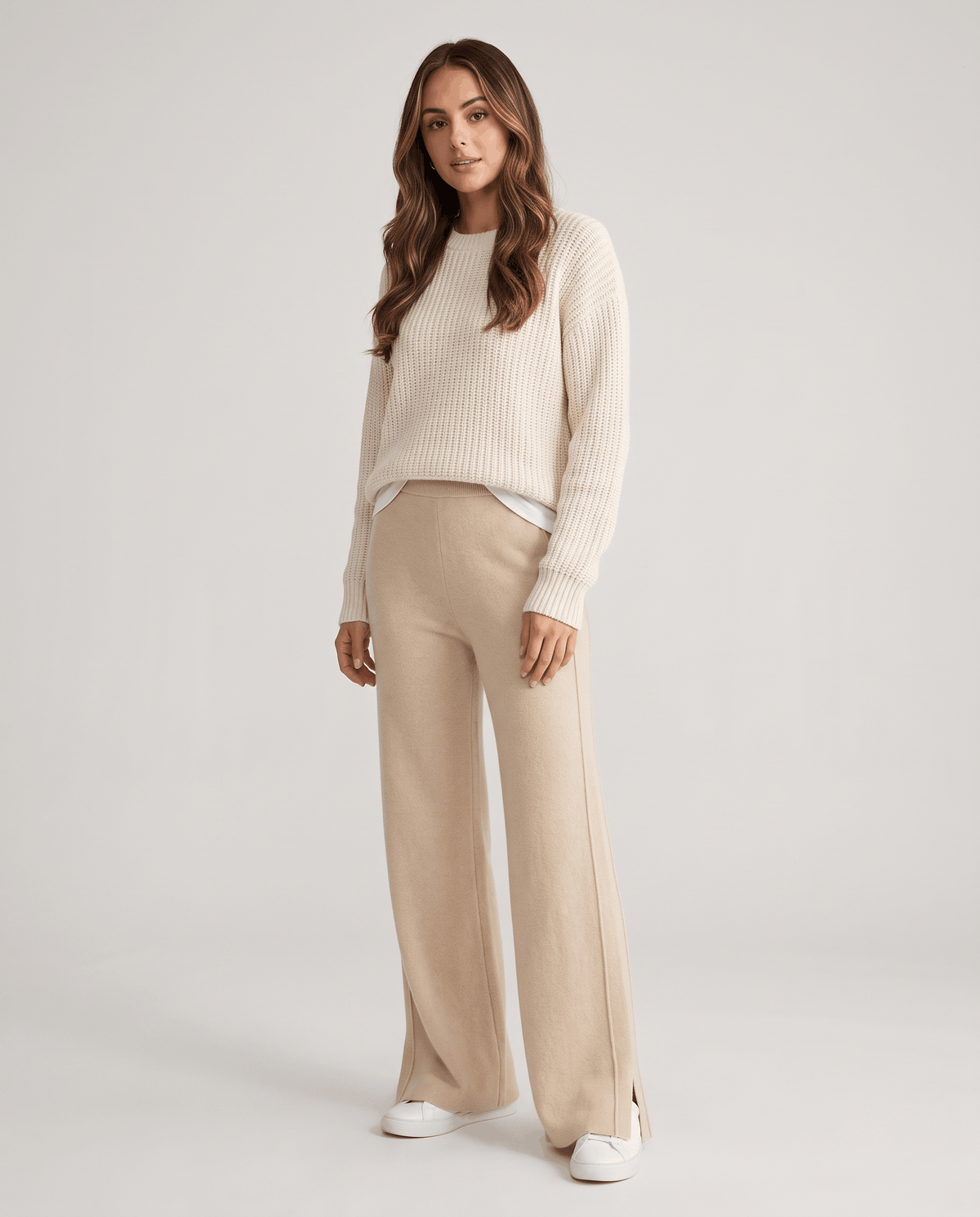 Model in cream cable sweater and beige wide straight-leg knit pants
