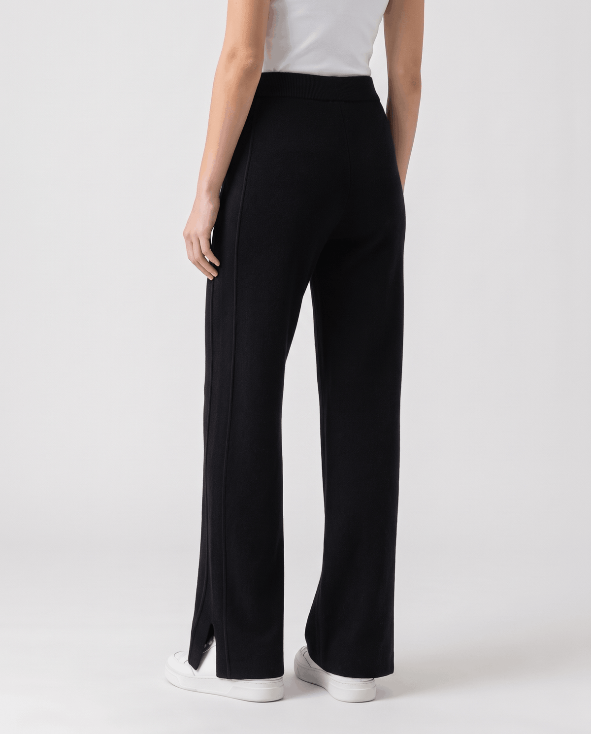 Back view of black straight-leg pants with center seam and hem slits