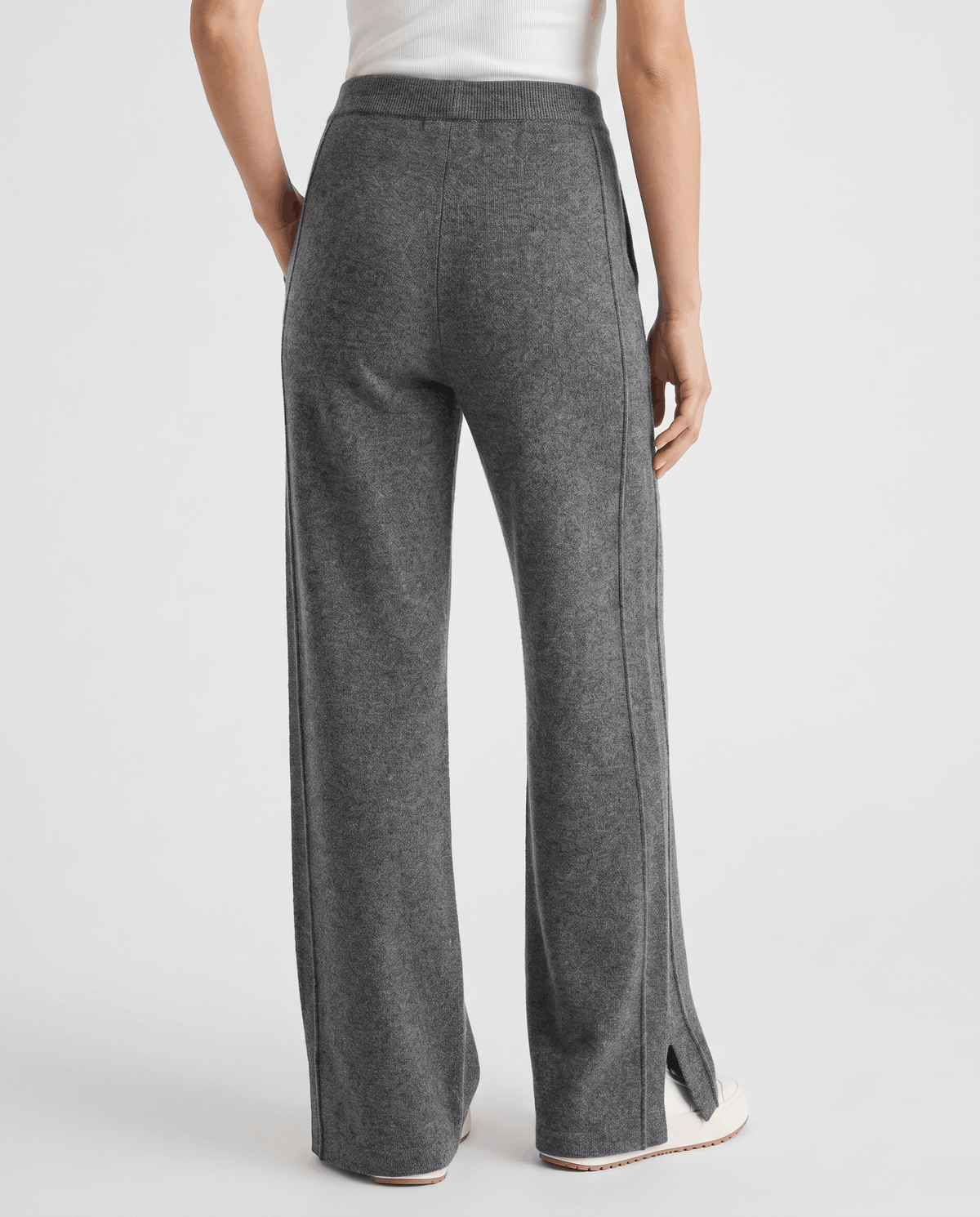 Back view of gray straight-leg pants showing seam lines and split hems