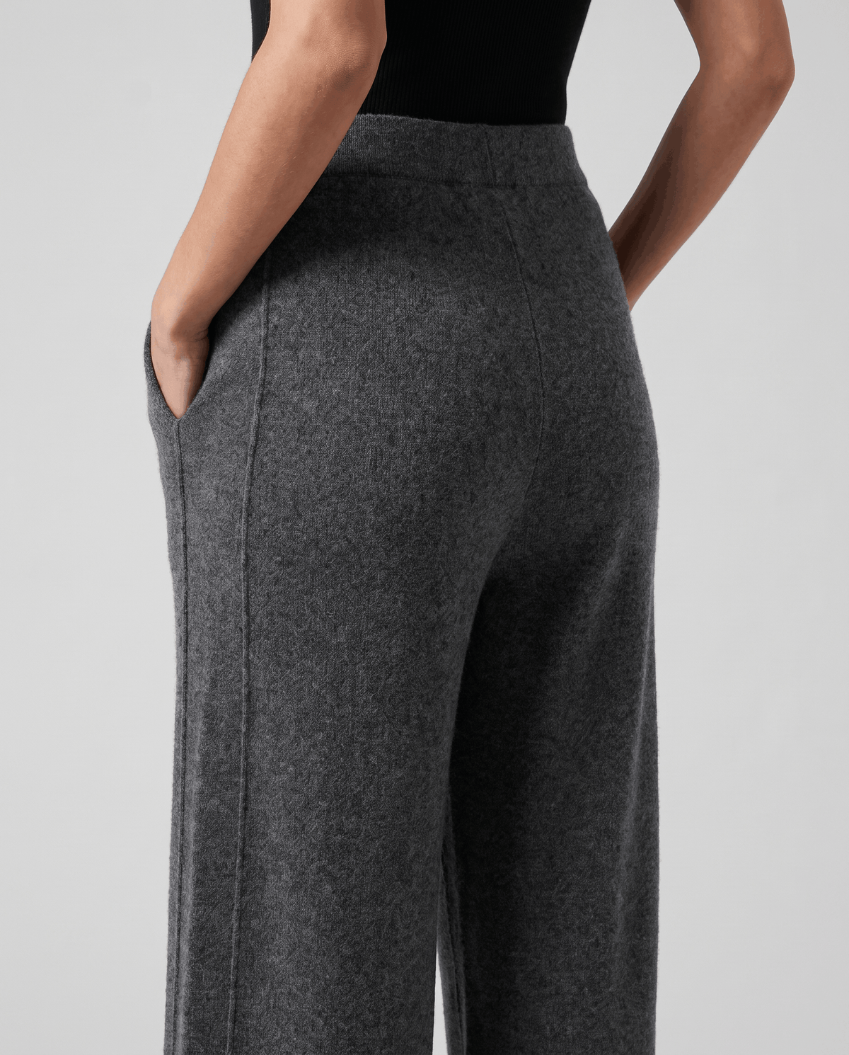 Close-up of gray knit fabric at the back with hand in side pocket