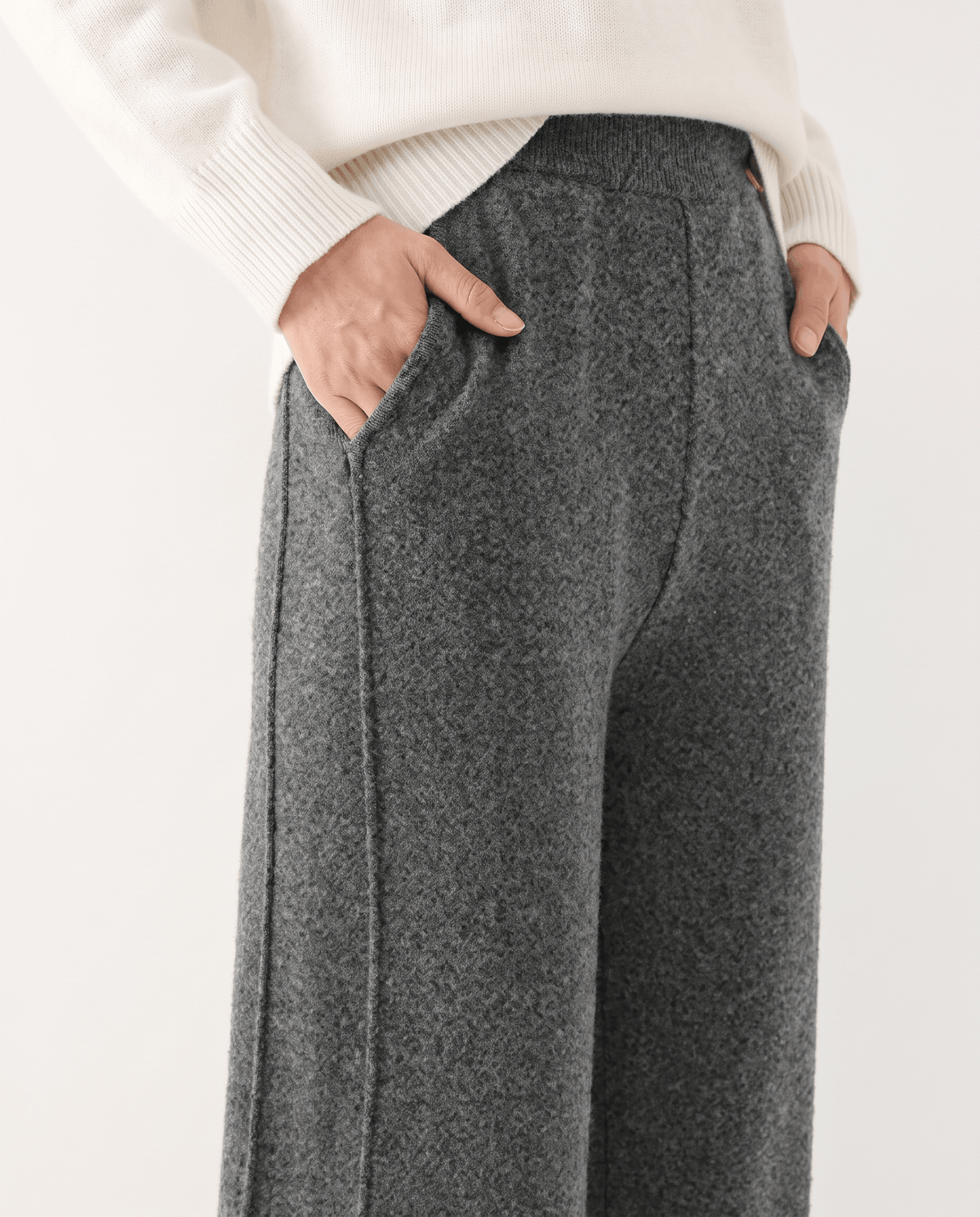 Front detail of gray herringbone-look knit with both hands in pockets