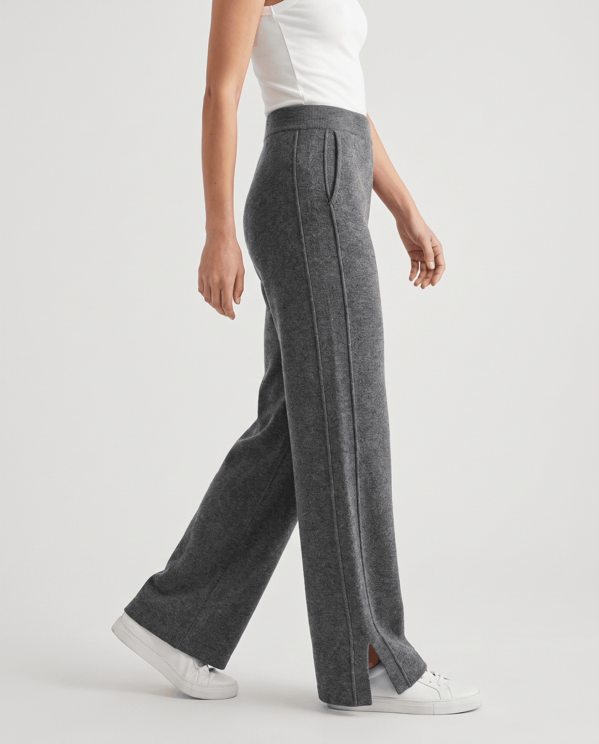 Gray heathered knit pants in side profile, mid-stride with white sneakers