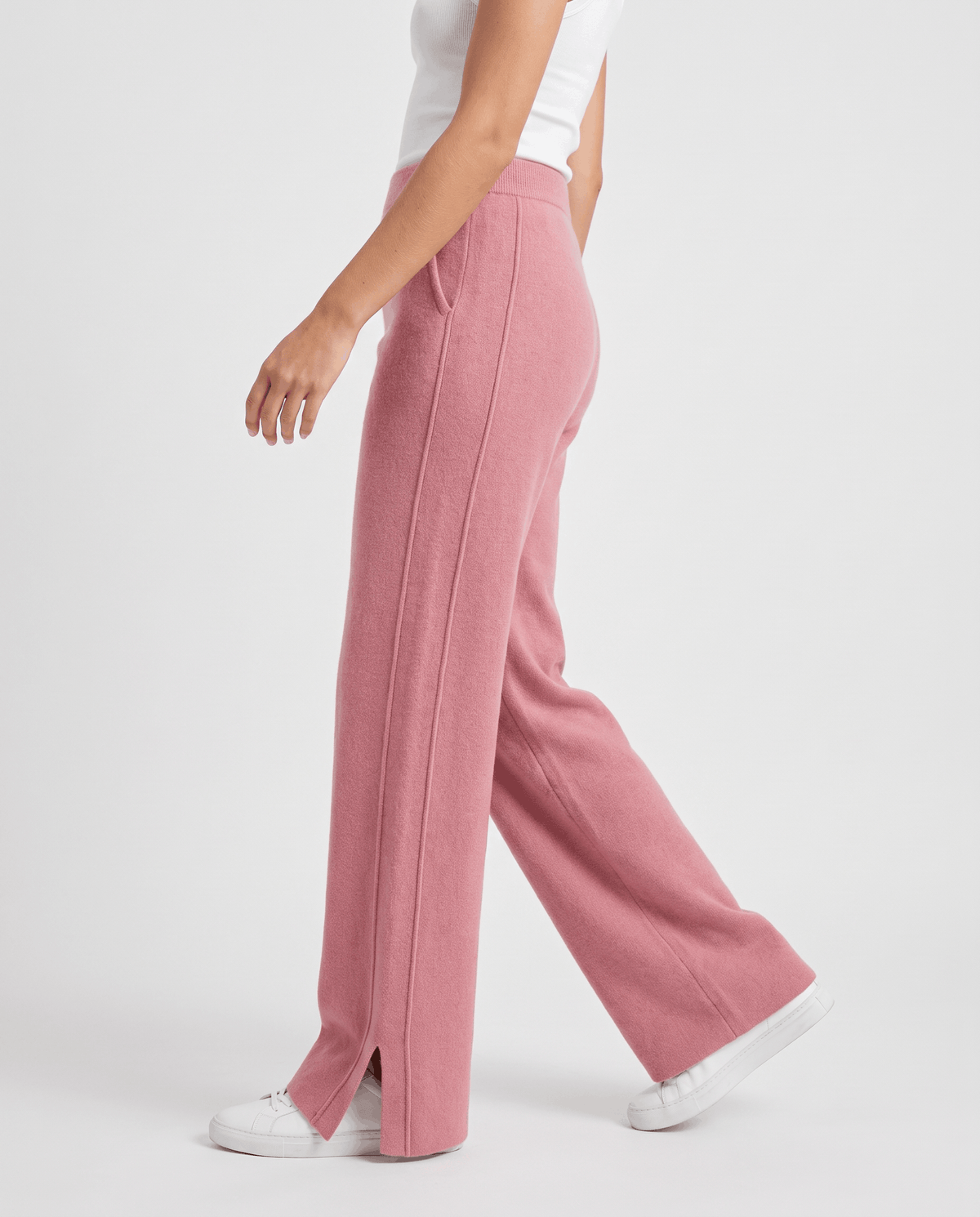 Rear side view of pink straight-leg pants mid-stride with hand in pocket