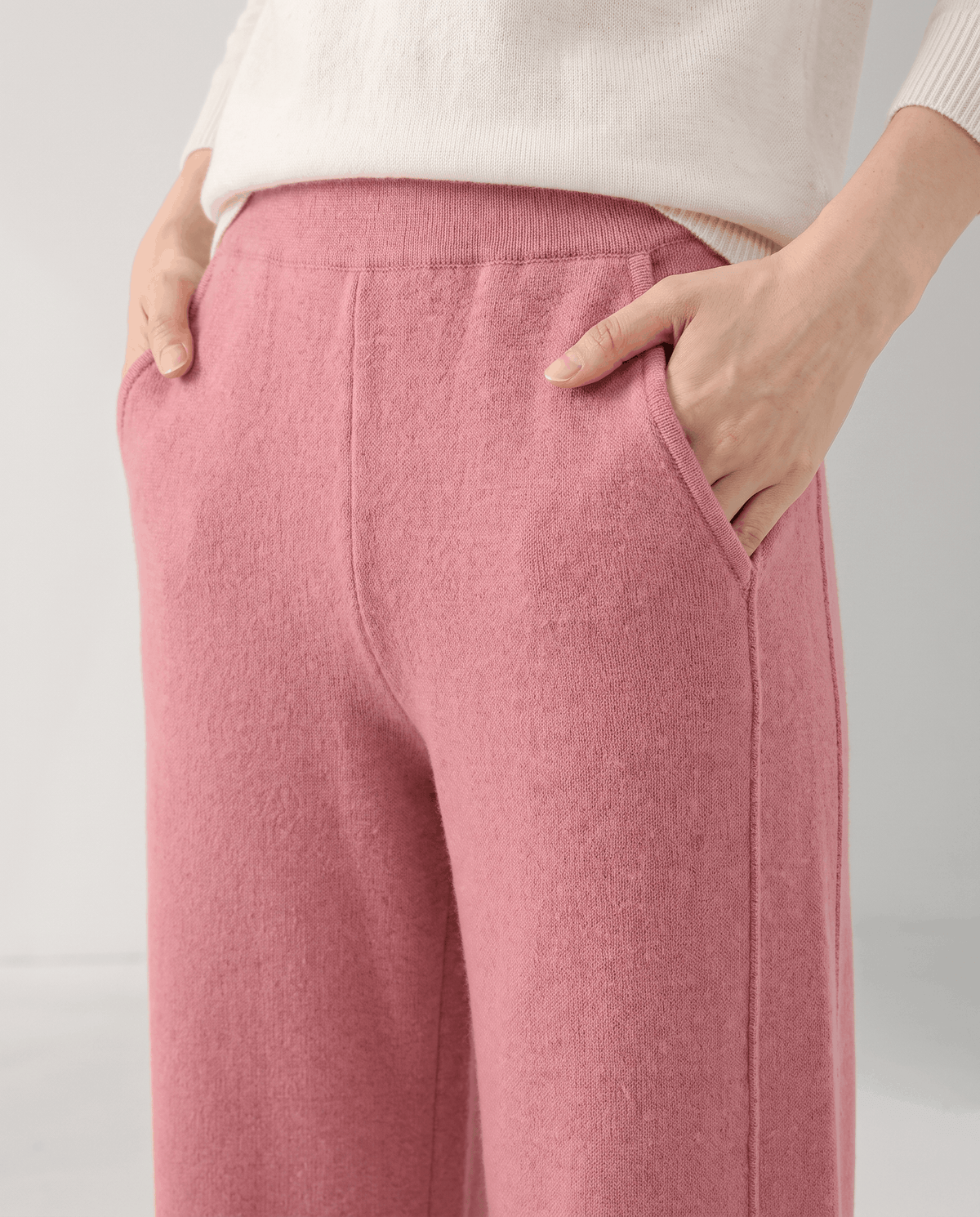 Front close-up of pink ribbed waistband with both hands in side pockets
