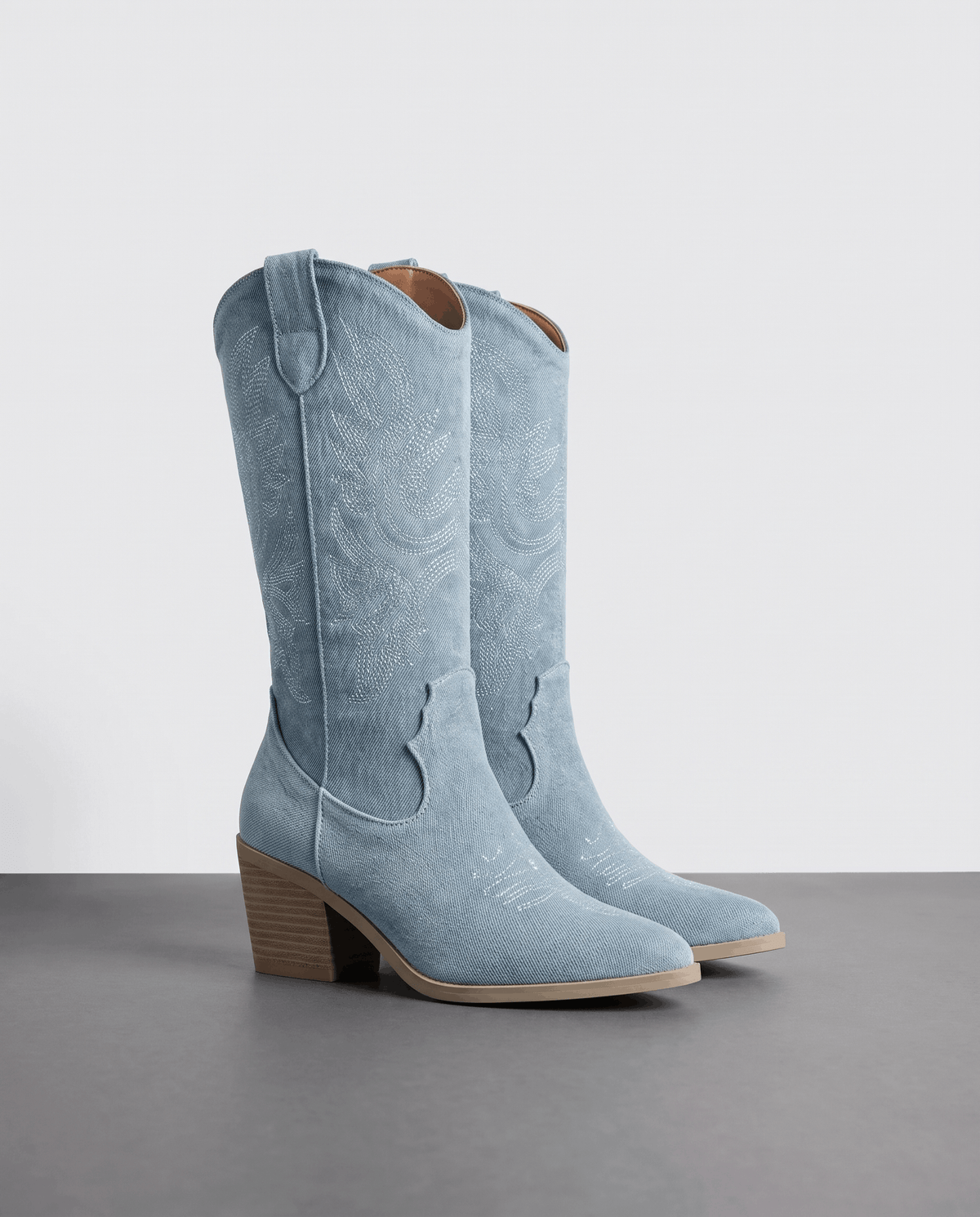 Pair of women's tall cowboy boots in light blue with stitched shaft and block heel