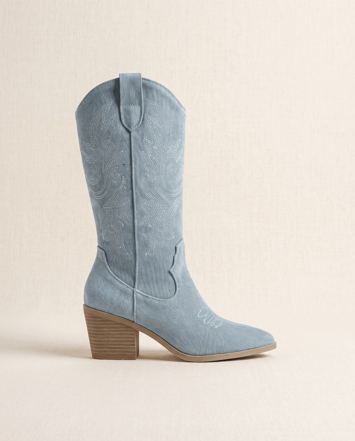 Side view of a single light blue boot with stitched shaft, pointed toe and block heel