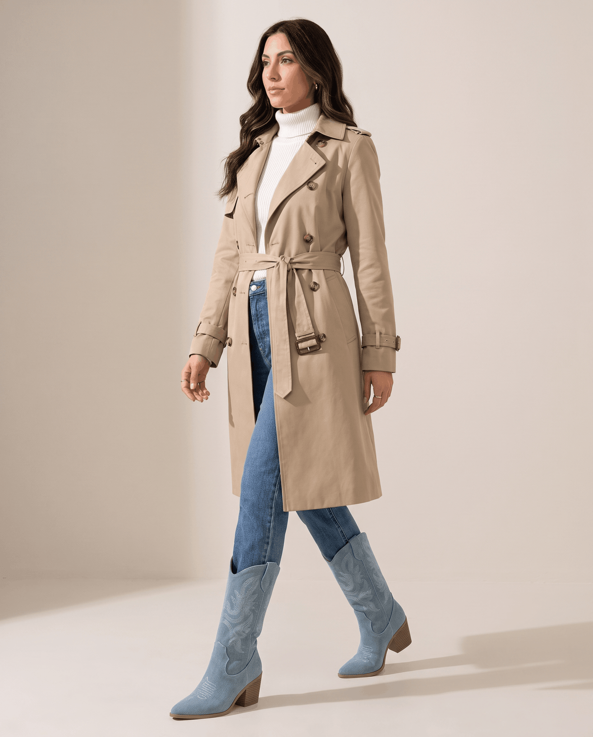 Woman in camel trench coat and jeans wearing light blue boots, full length