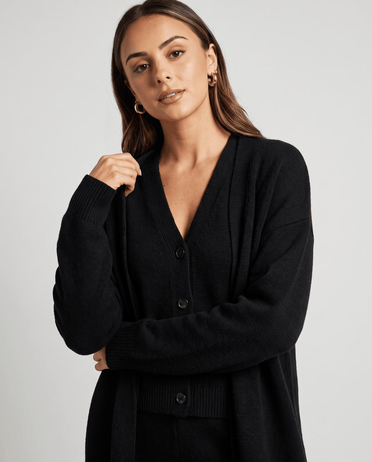 Close-up of the V-neckline and buttons on the black knit vest