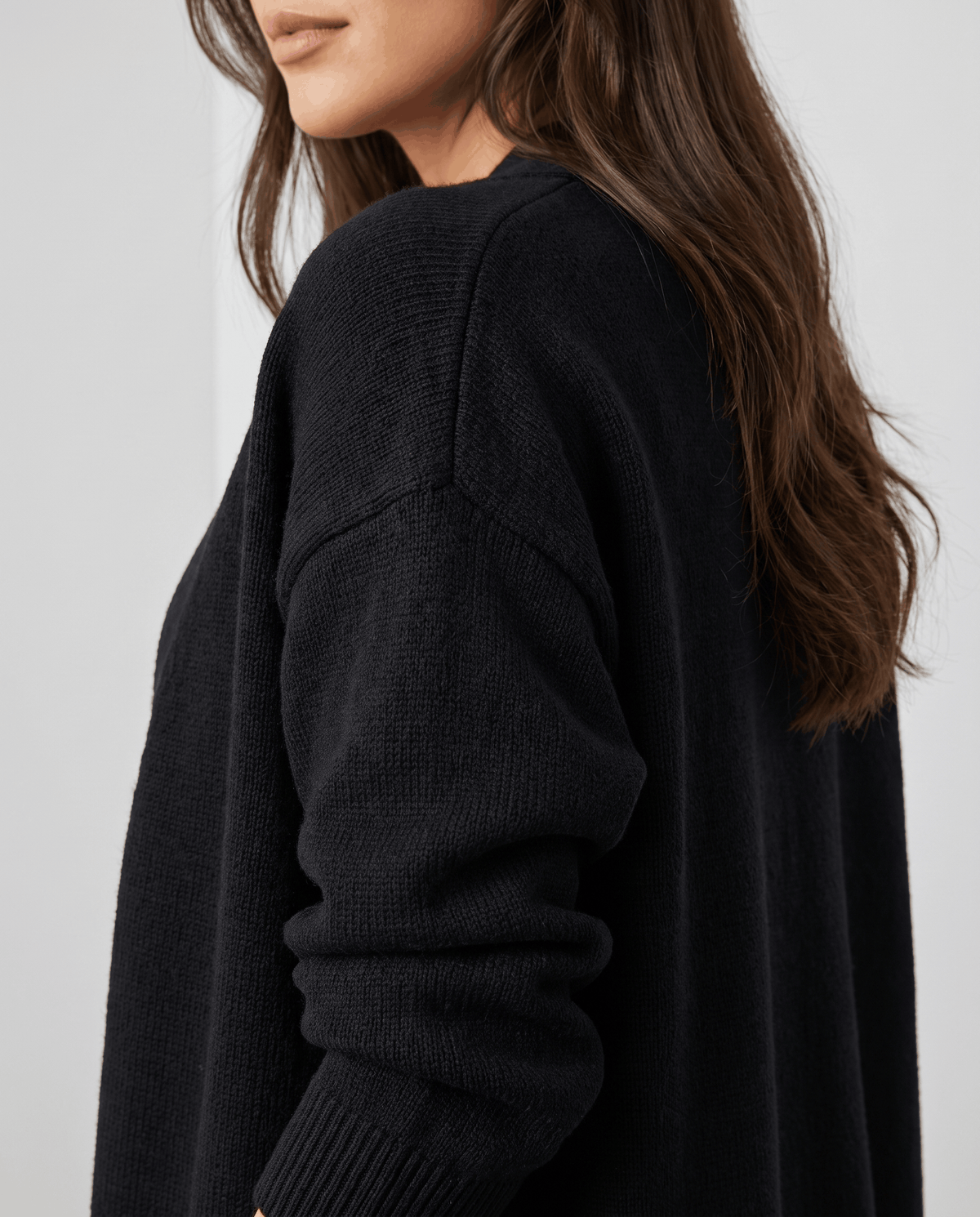 Close-up of the dropped shoulder on the black cardigan coat