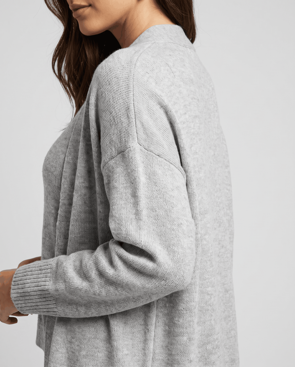 Side close-up of the dropped shoulder and ribbed cuff on the light gray cardigan coat