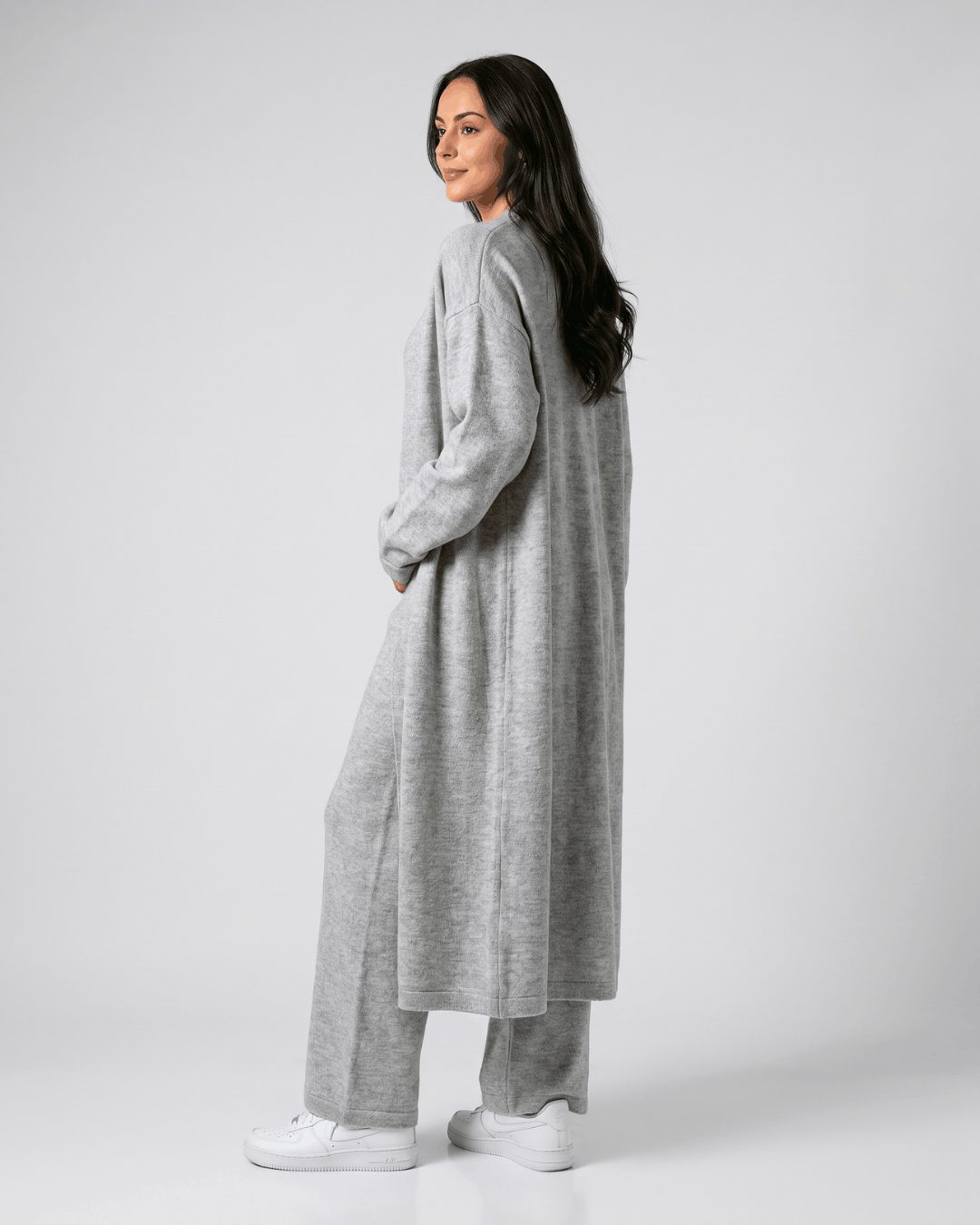 Side view of the light gray long cardigan coat worn over wide-leg pants