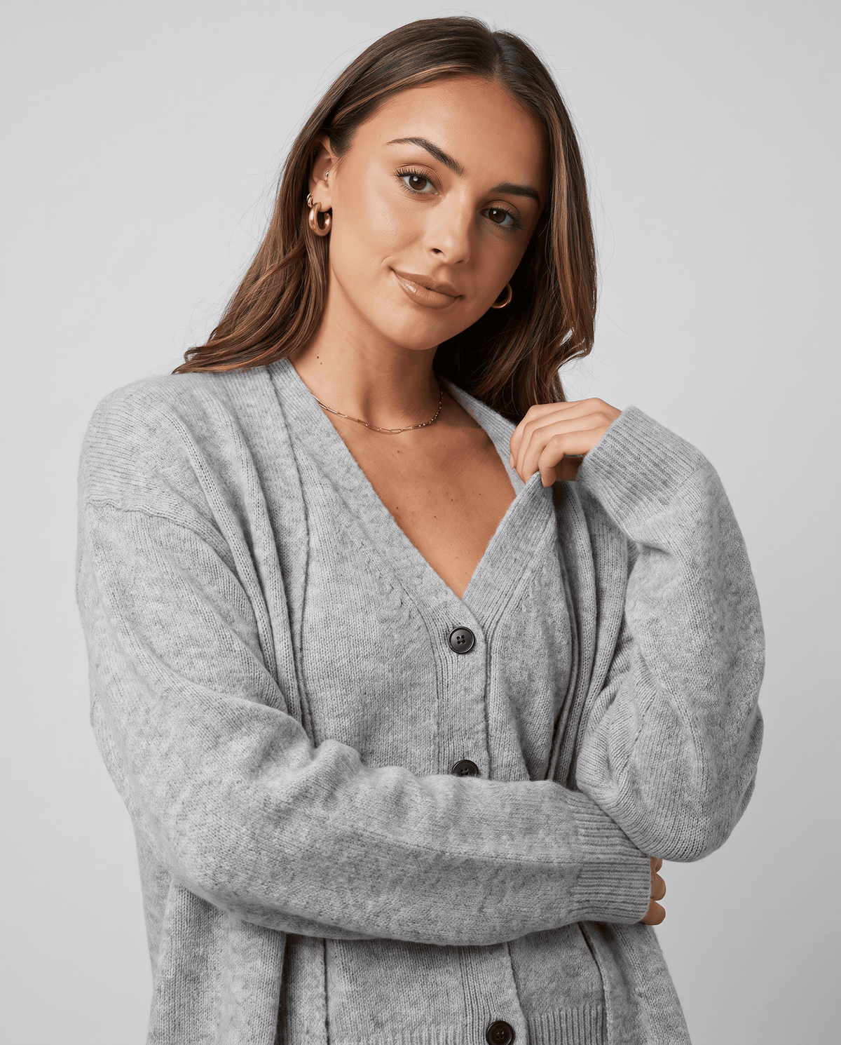 Close-up of the V-neck button-front vest under the light gray cardigan coat