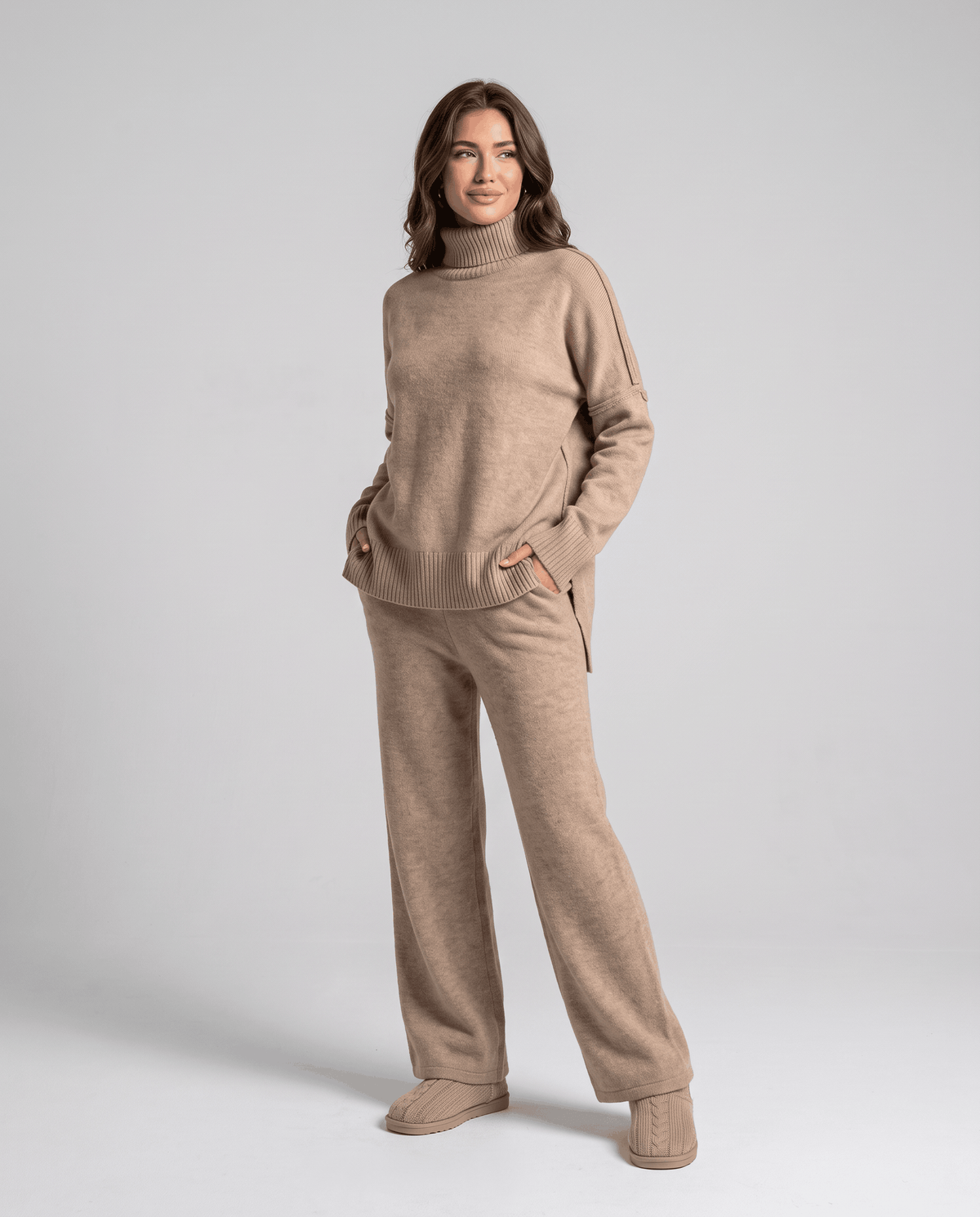 Beige oversized turtleneck sweater and wide-leg pants, three-quarter view with hands in pockets
