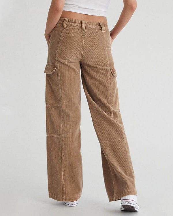 Angled front view of washed camel ribbed trousers showing the thigh flap pockets