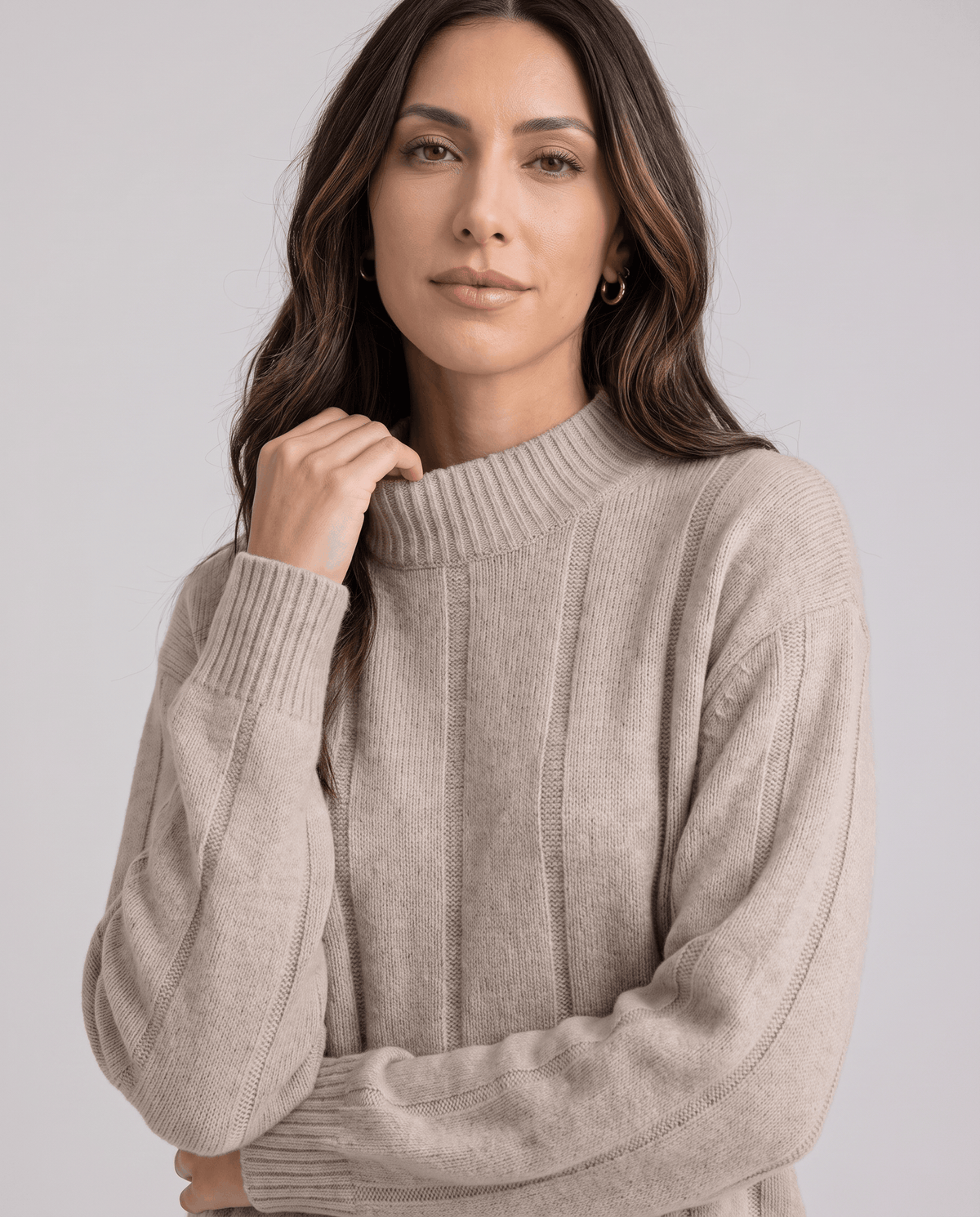 Model with hand at the mock neck, showing the ribbed sleeve and cuff