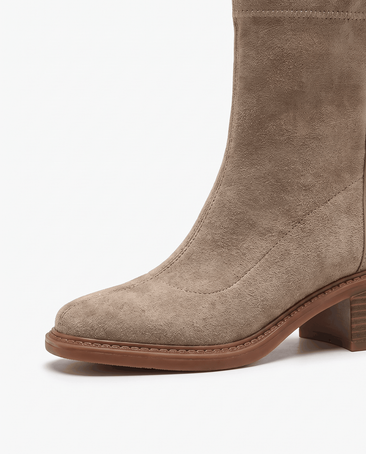 Close-up of the rounded toe and sole of a beige suede ankle boot