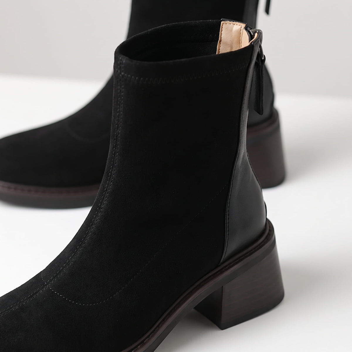 Close-up of the stretch shaft and suede texture on a black ankle boot