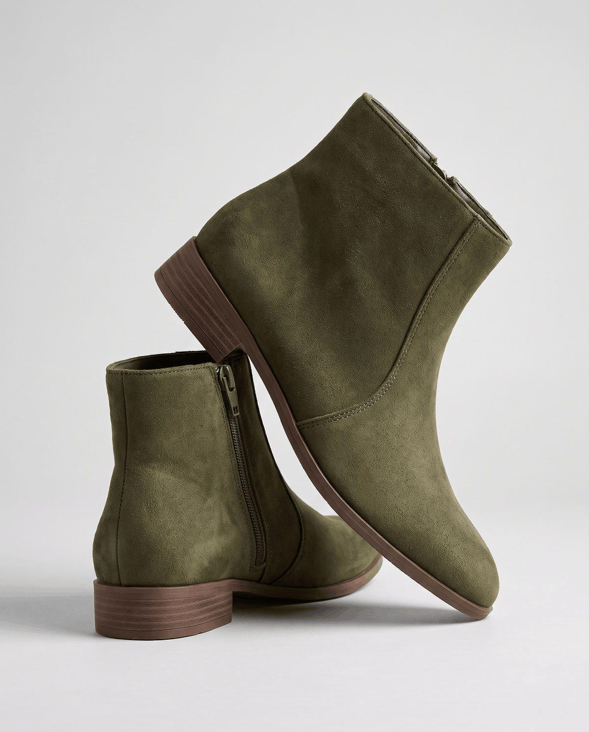 Olive green suede-look ankle boots stacked to show the heel and zip