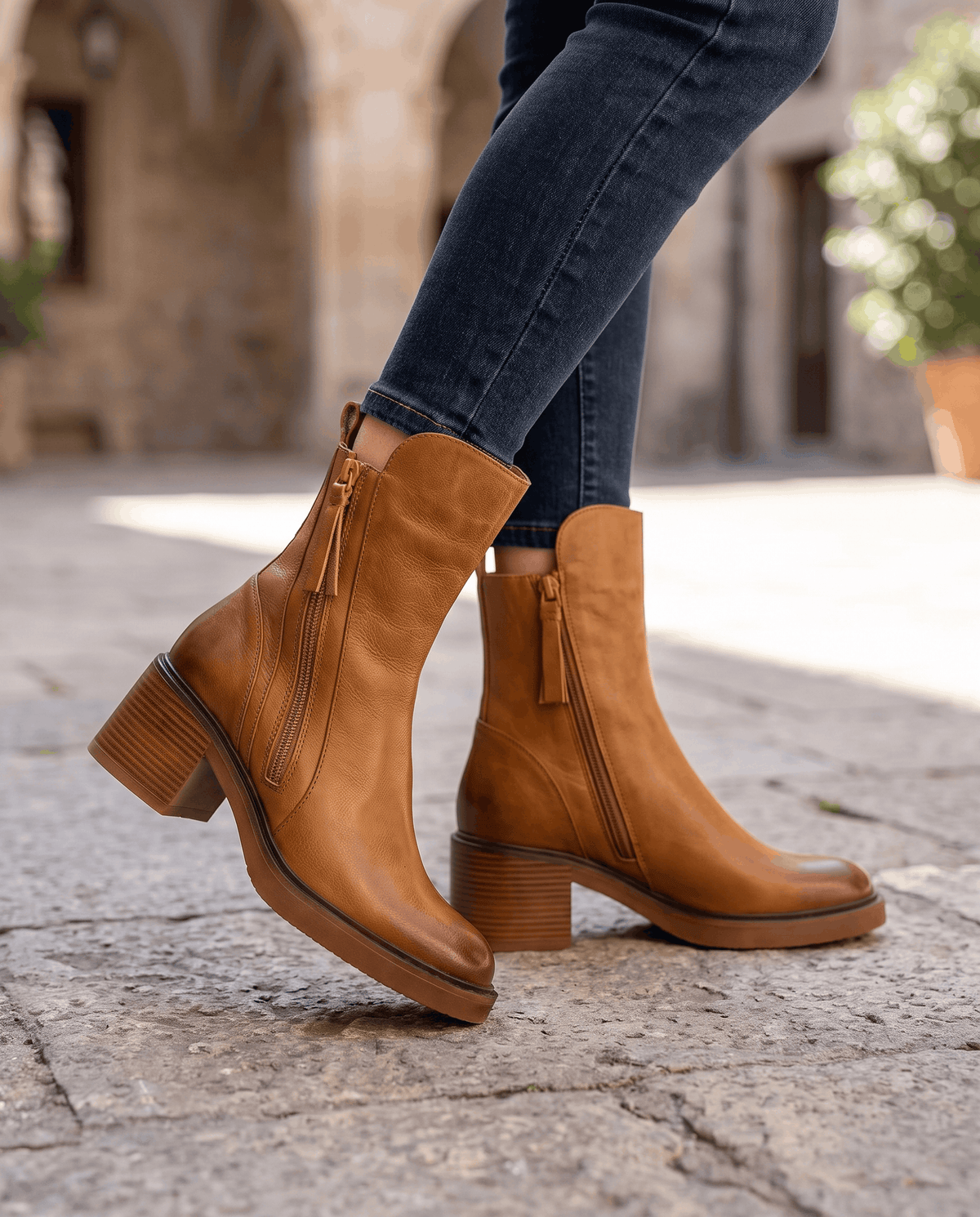 Woman walking in brown block heel ankle boots with blue jeans outdoors