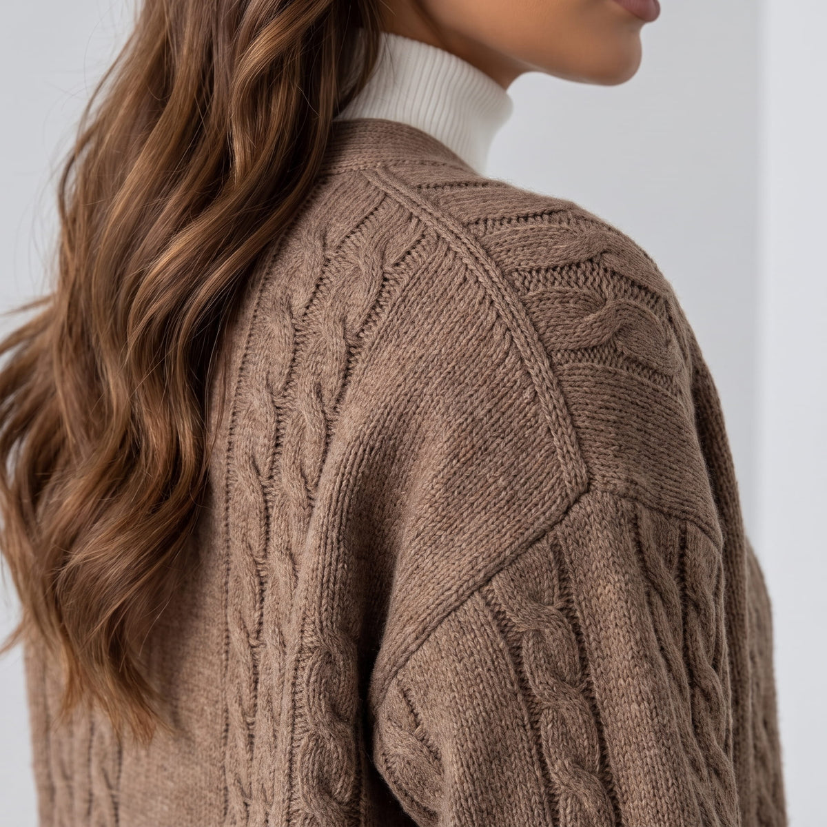 Close side view of camel cable-knit cardigan sleeve and shoulder