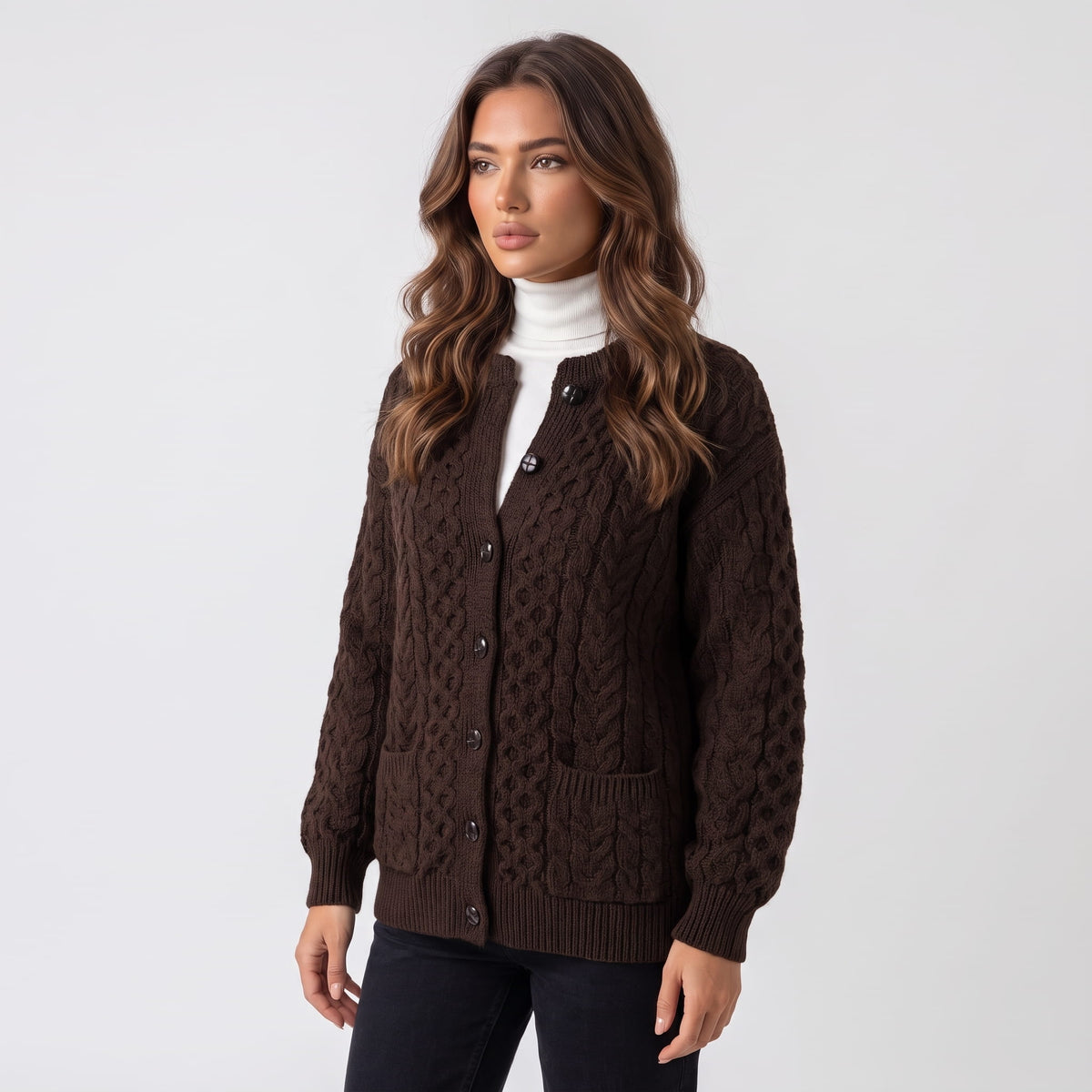 Women's dark brown cable-knit button cardigan worn over a white turtleneck