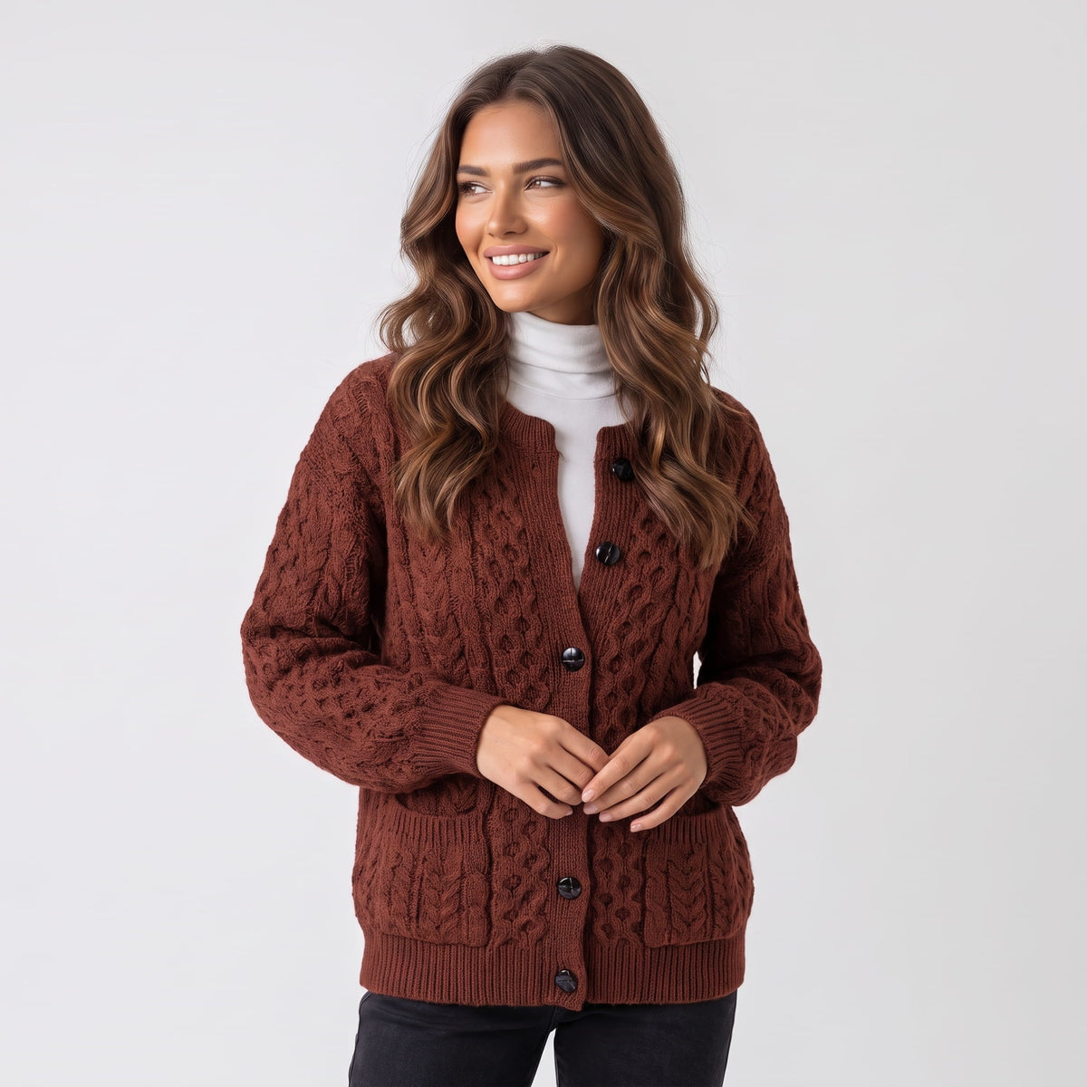 Women's maroon cable-knit button cardigan worn over a white turtleneck