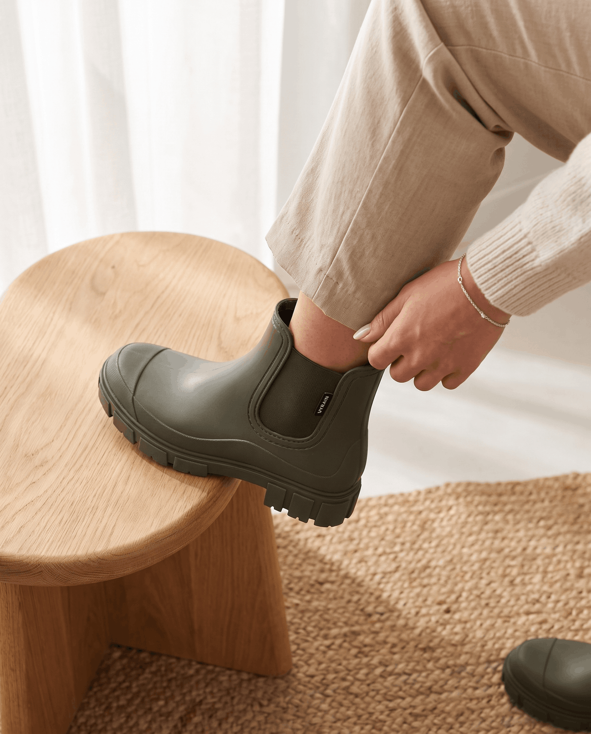 Green Chelsea boots with chunky lug soles worn with a denim skirt.