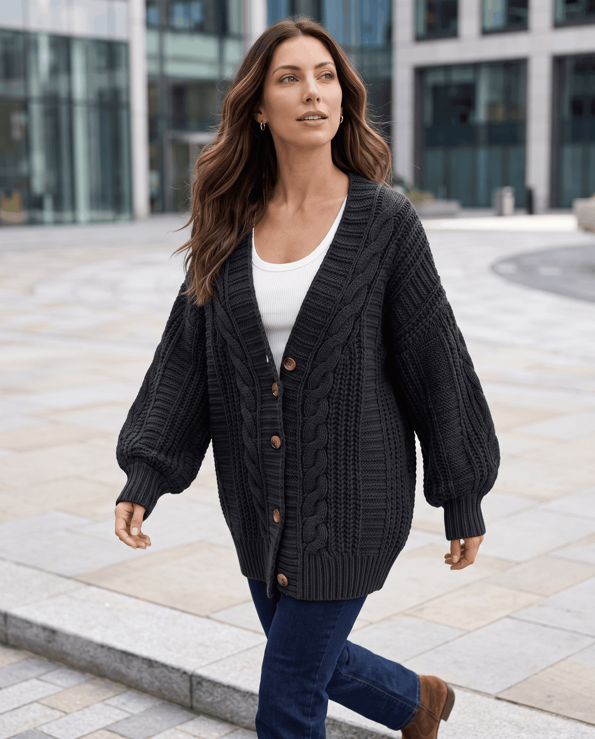 Charcoal cable knit cardigan styled with jeans on a city street